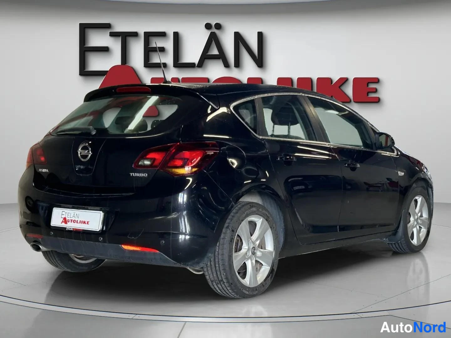 Takaviisto: Musta farmari kolmivärisenä takanäkymänä: Opel Astra Turbo