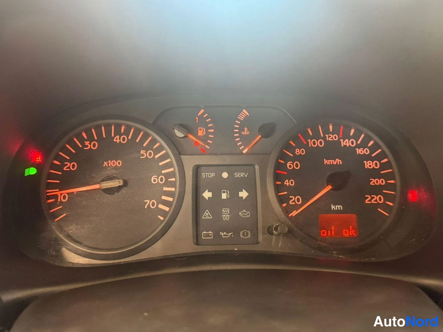 Muu: Auton mittaristo sytytettynä: nopeus- ja kierrosmittarit asteikolla 220 km/h, näytössä teksti 'oil ok' ja useita varoitusvaloja palaa.