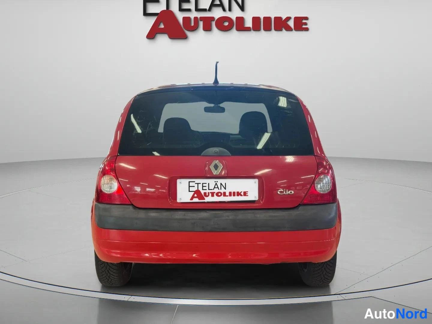Takaa: Punaisen Renault Clio:n takanäkymä studiossa, takavalot ja Etelän Autoliike -kyltti näkyvät.