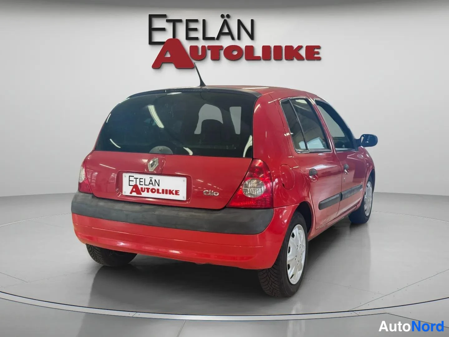 Takaviisto: Punaisen Renault Clio:n takakulmanäkymä studiossa, oikea sivu ja takapuskuri näkyvät.