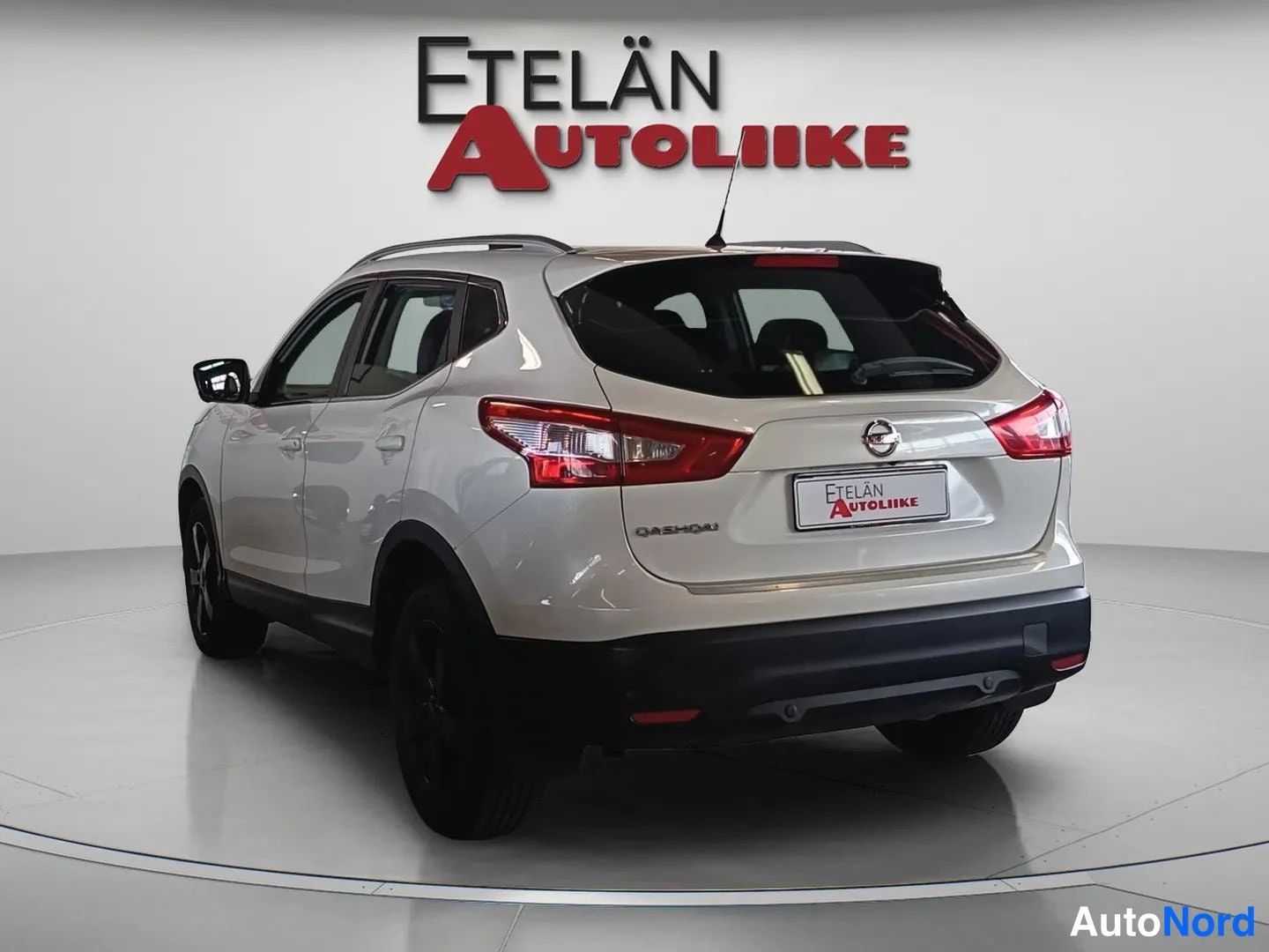 Takaviisto: Valkoinen Nissan Qashqai taka kolmannesvinkkelistä, takavalot ja Qashqai-merkki näkyvät