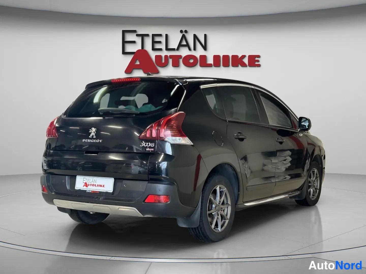 Takaviisto: Auton takakulmanuva musta Peugeot 3008 -malli studiossa, jossa näkyvät takavalot, rekisteritunnus ja takarenkaat