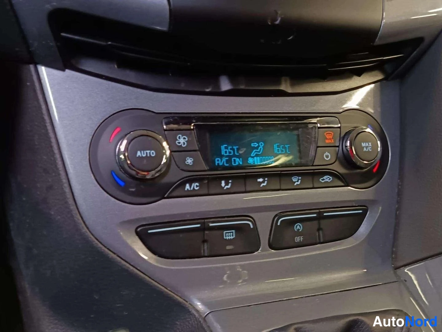 Muu: Kaksivyöhykeinen automaattinen ilmastointipaneeli, näytöllä 16,5 °C molemmilla puolilla, teksti A/C ON, A/C- ja MAX A/C-napit.