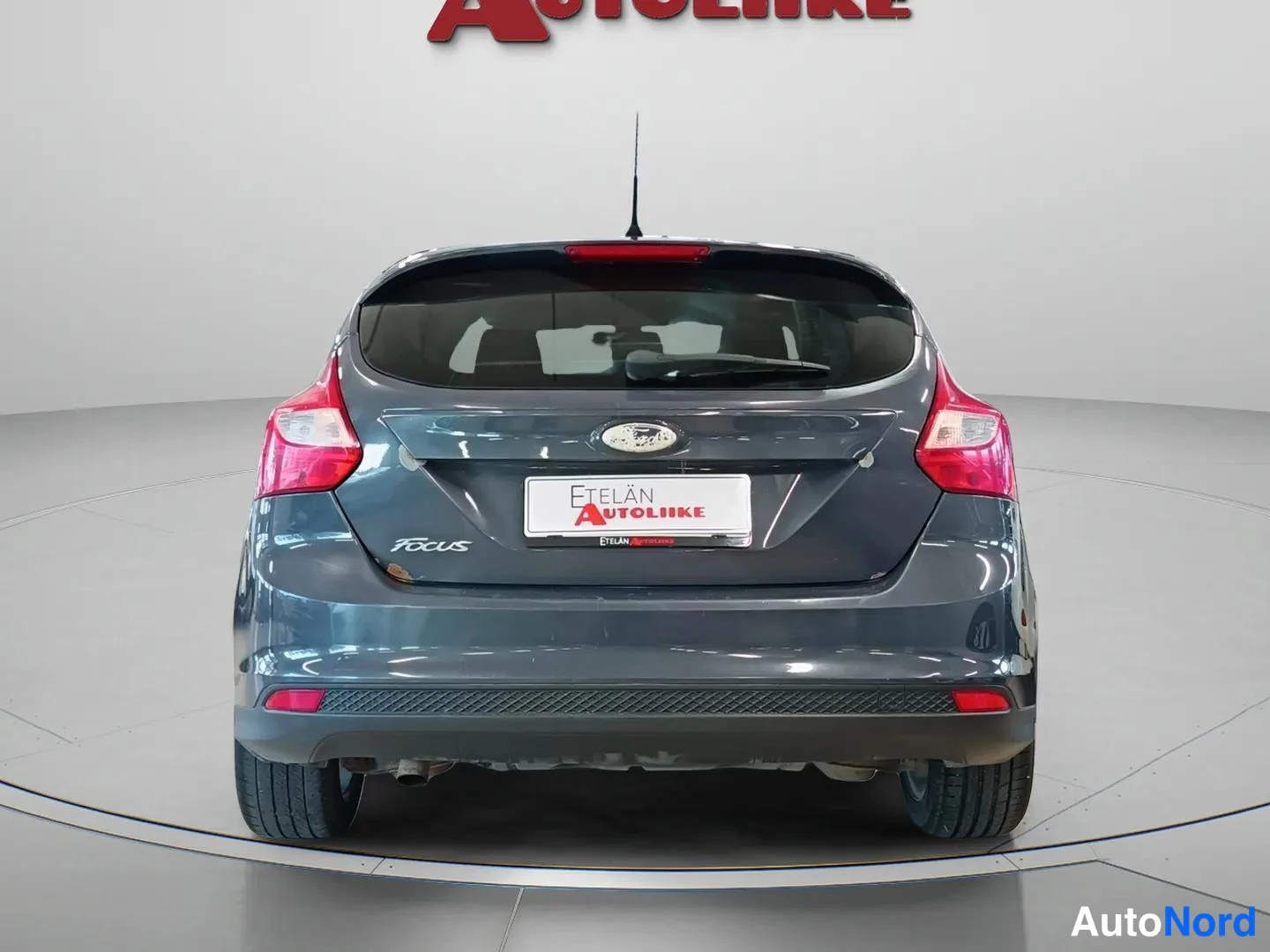Takaa: Auton takaosa suoraan takaa: tummanharmaan auton takavalot, Ford-merkki ja Focus-teksti.