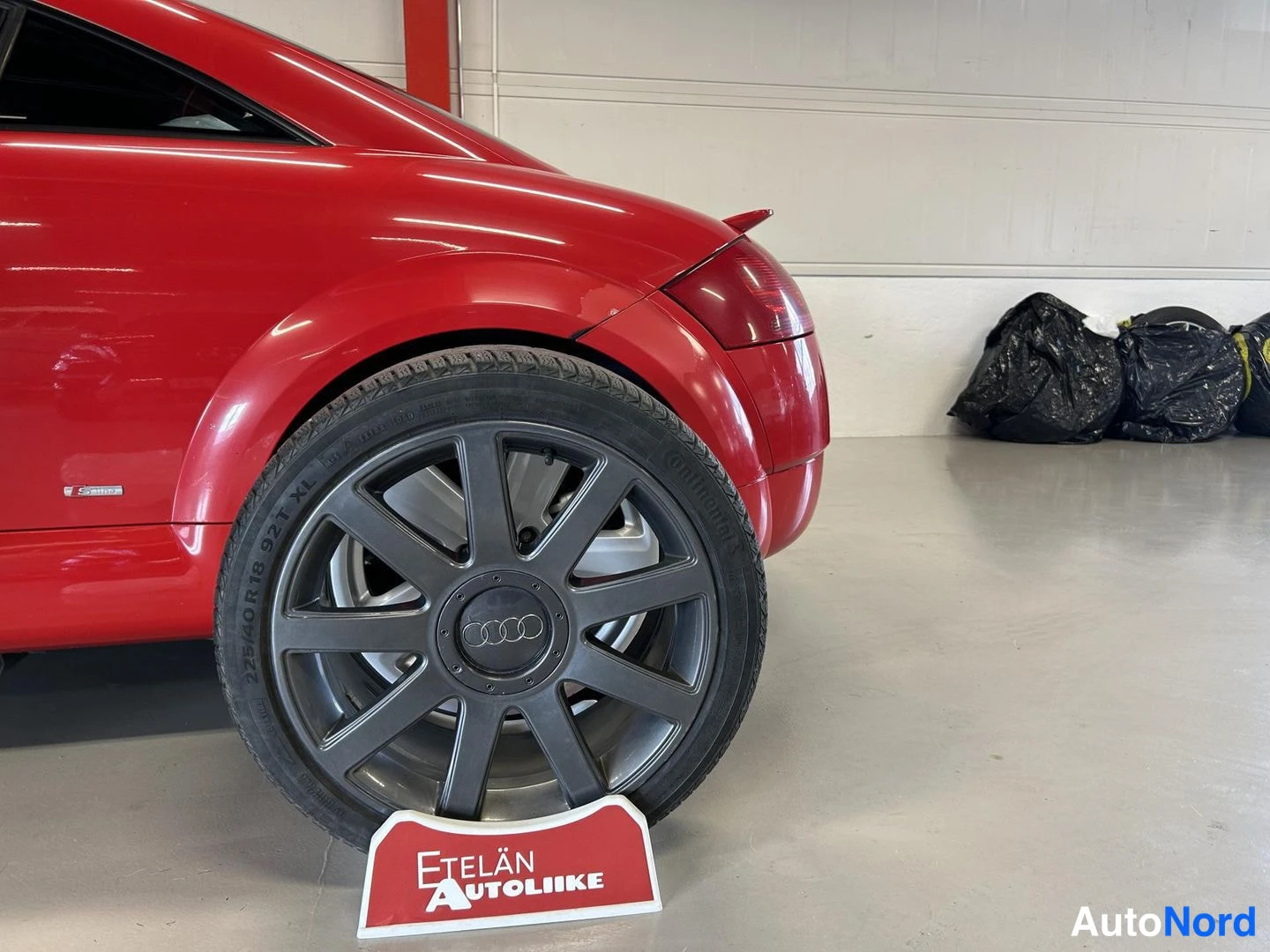 Takaviisto: Punaisen auton takapyörä tummalla Audi-vanteella, renkaassa 225/40R 18 92Y XL, alla Etelän Autoliike -kyltti