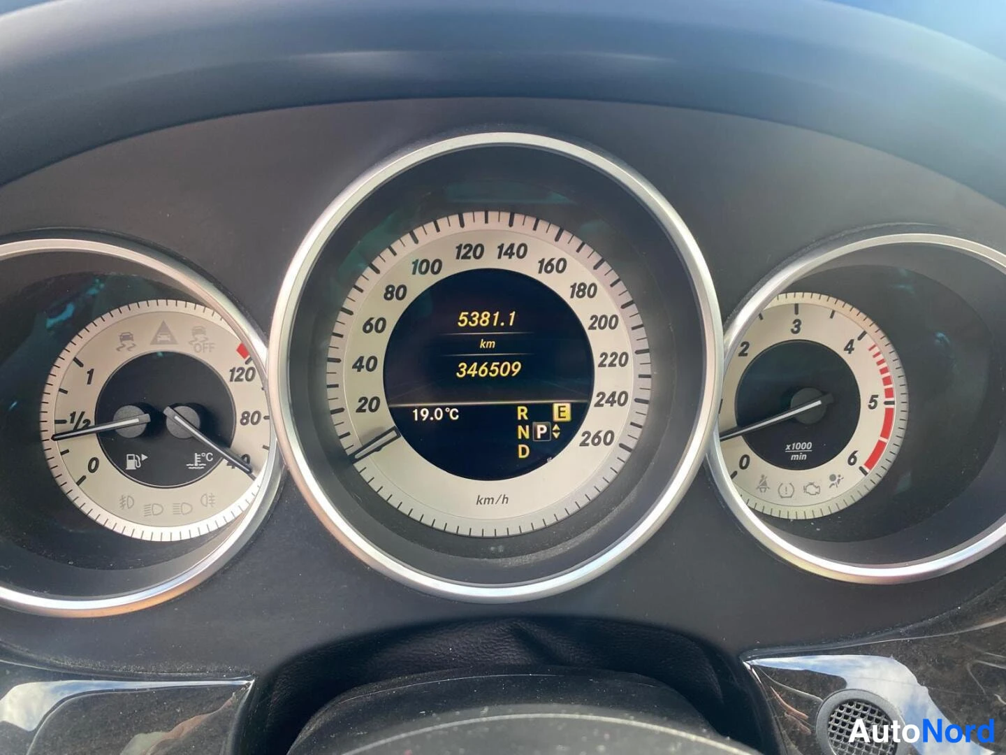 Yksityiskohta: Auton mittaristo: nopeusmittari 0–260 km/h, polttoaine- ja lämpömittari vasemmalla, kierrosmittari oikealla; näytössä lukemat 5381,1 km, kokonaislukema 346509 k