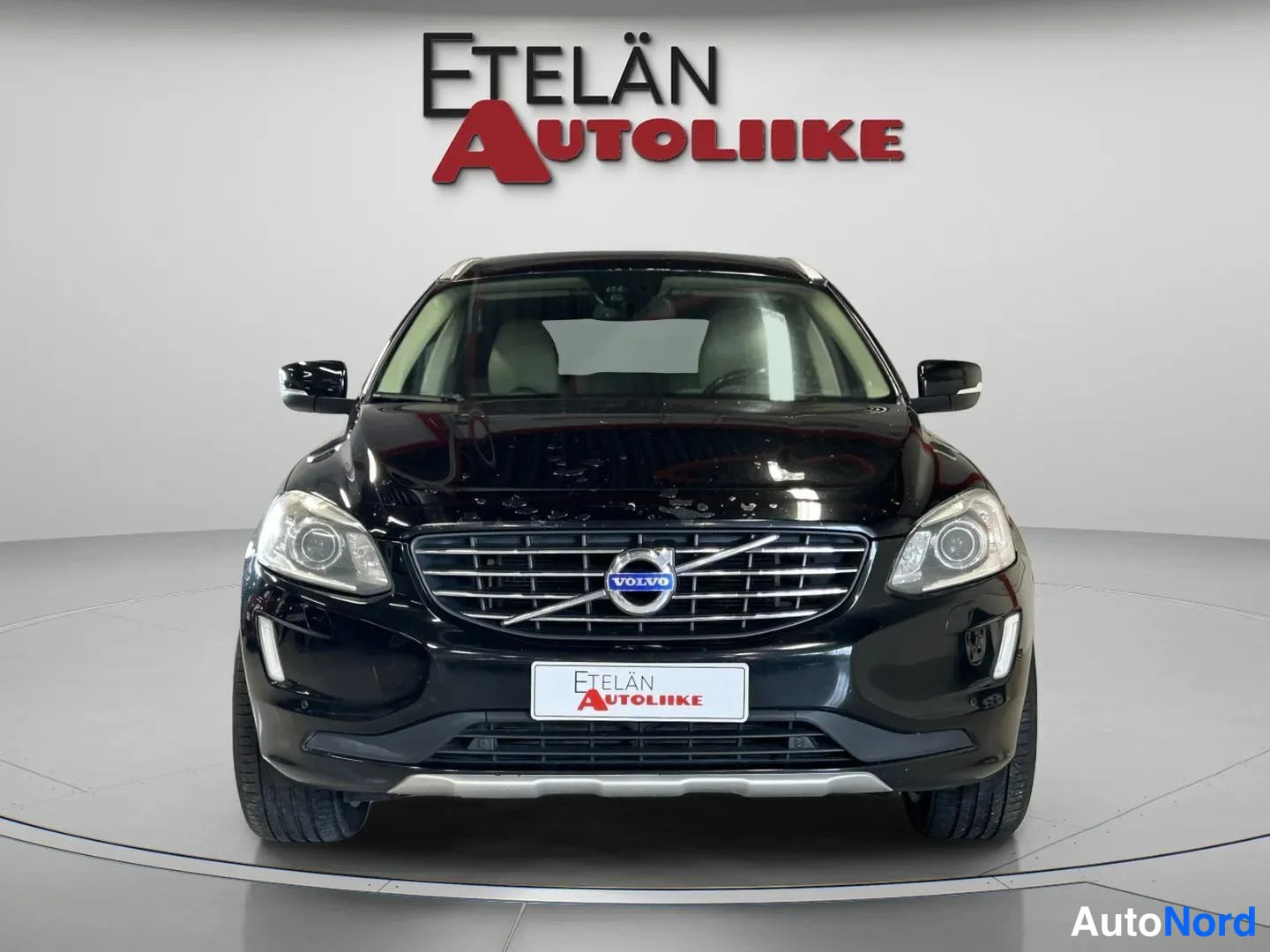 Edestä: Mustan auton etunäkymä suoraan edestä, Volvo-merkki säleikkössä ja Etelän Autoliike -kyltti etupuskurissa.