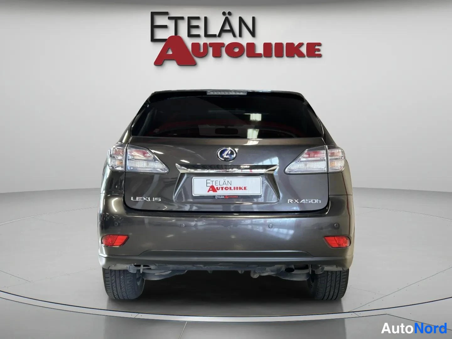Takaa: Tummanharmaan Lexusin takaosa suoraan takaa, takaluukussa LEXUS- ja RX 450h -merkinnät.
