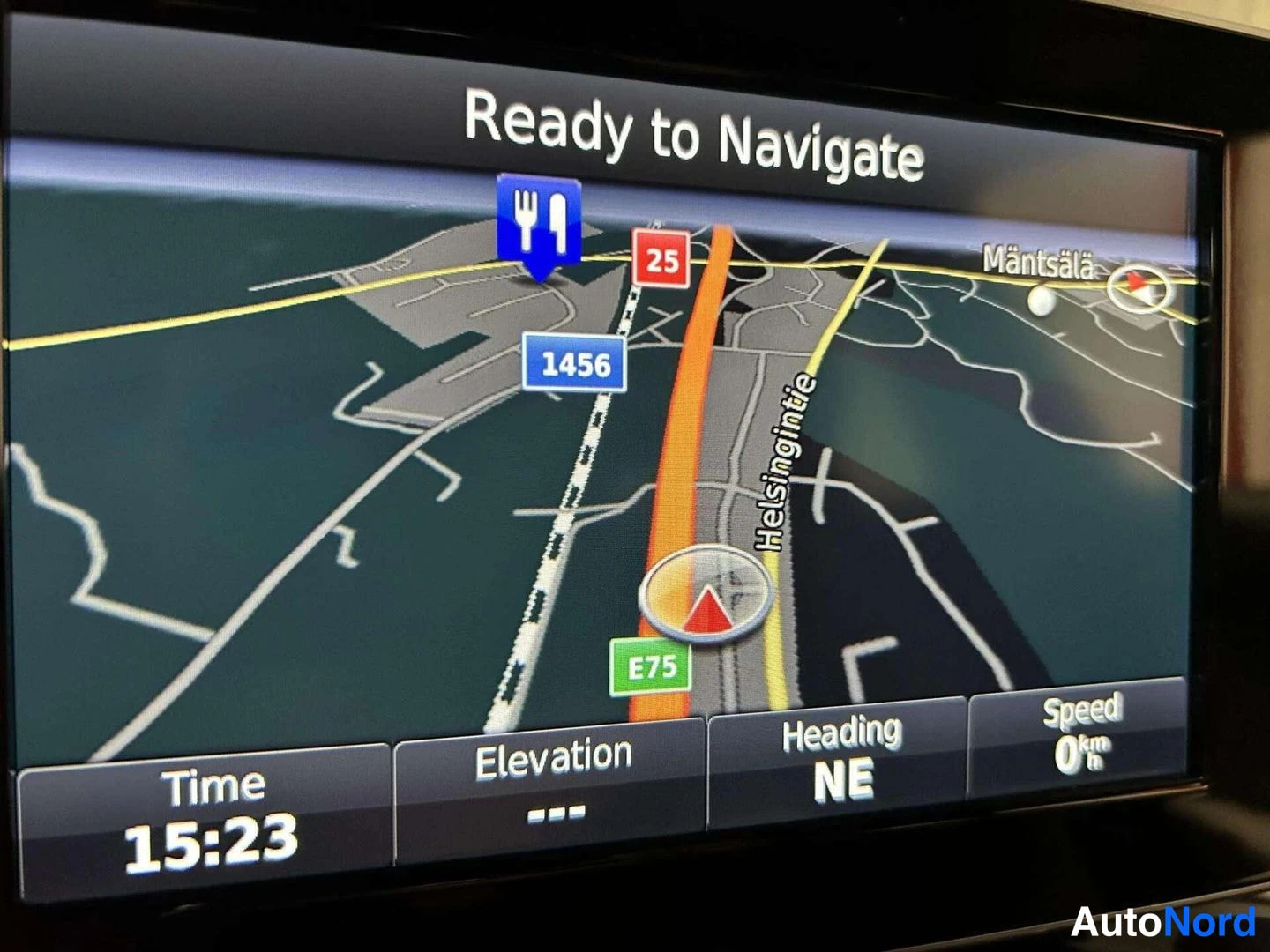 Muu: Auton infotainment-näyttö näyttää navigaattorin karttaan alaviivalla 'Ready to Navigate'; alarivissä Time 15:23, Elevation ---, Heading NE ja Speed 0 km/h.