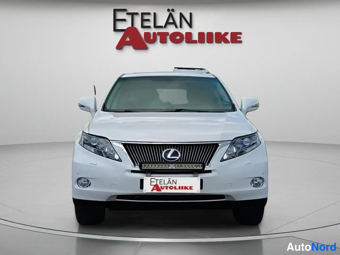 Edestä: Valkoisen auton etunäkymä suoraan edestä, Lexus-merkki konepellin alla, Etelän Autoliike -kyltti rekisterin paikalla.