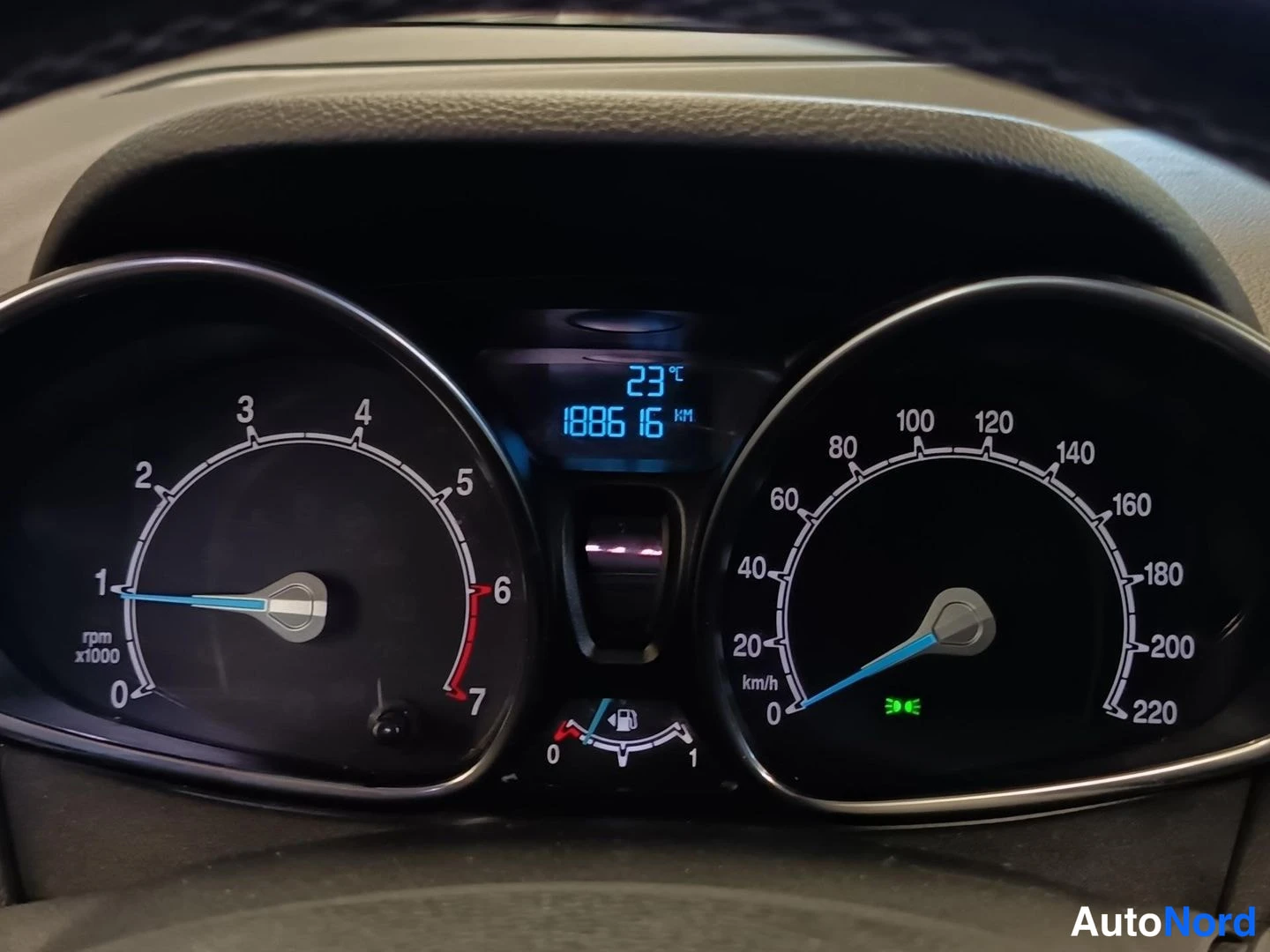 Yksityiskohta: Close-up of the instrument cluster showing the speedometer on the right, tachometer on the left and a digital display between them reading 188616 km.