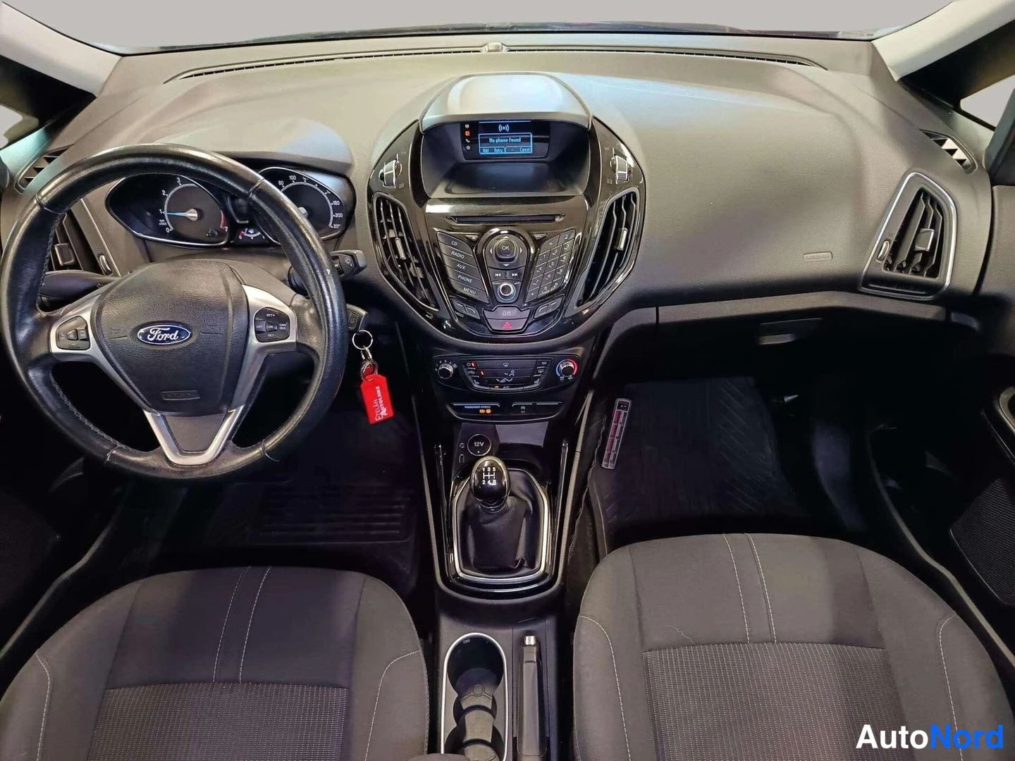 Etuistuimet: Interior cabin view looking forward from the driver's perspective, showing the steering wheel with Ford logo, instrument cluster, central infotainment screen ab