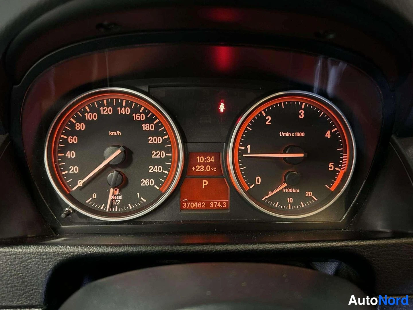 Yksityiskohta: Autojen kojelaudan mittaristo, jonka näyttö näyttää matkan 370462 km, vaihteen P ja polttoainemittarin diesel-merkinnän.