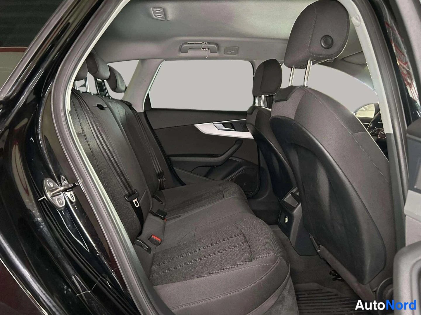 Takaistuimet: Rear passenger area with three dark fabric seats visible through the rear left door opening