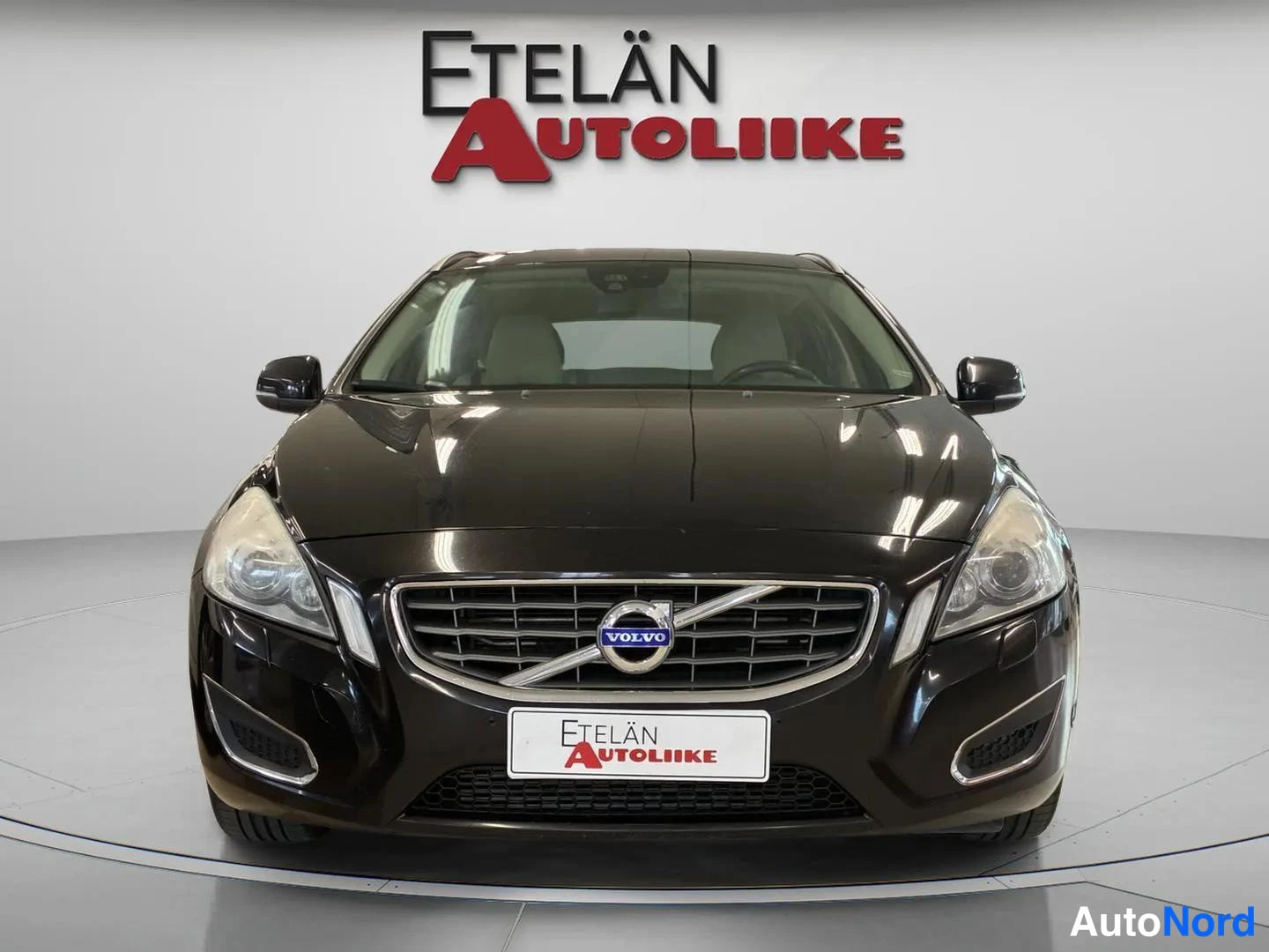 Edestä: Mustan farmariauton etunäkymä, Volvo-merkki säleikkössä keskellä.