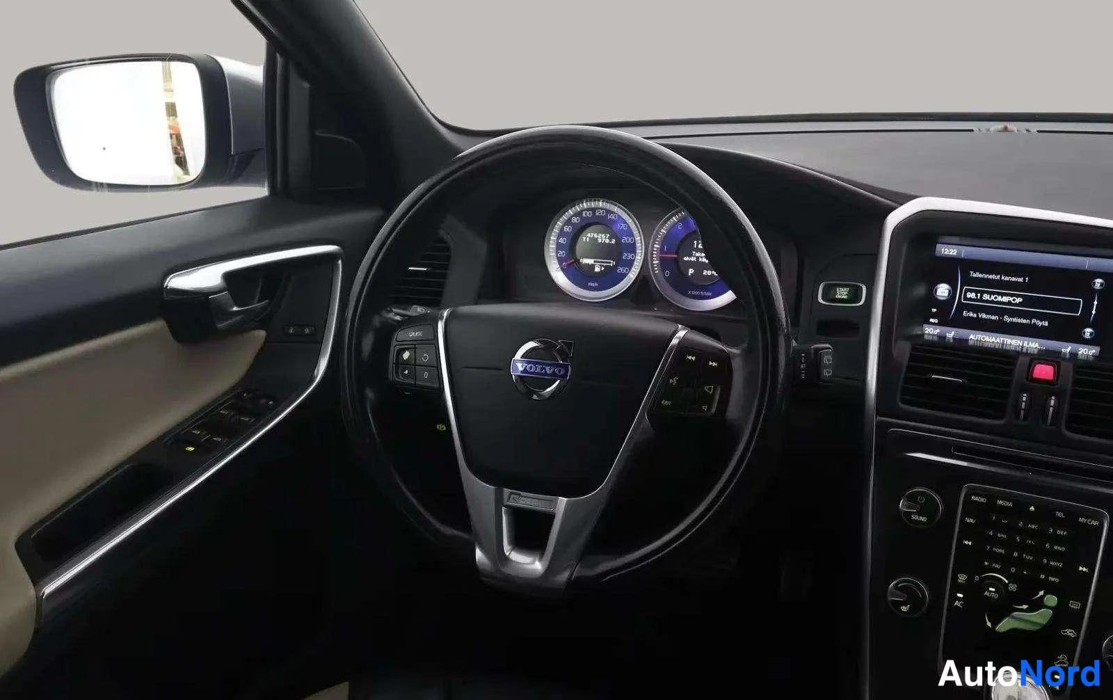 Muu: Volvo-henkilöauton ohjaamo: ohjauspyörä, mittarit ja keskikonsolin näyttö.