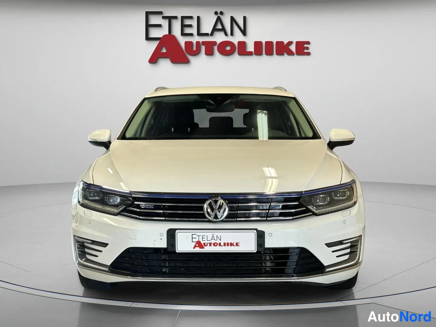 Edestä: Valkoinen Volkswagen Passat GTE -farmariauto suoraan edestä kuvattuna, Etelän Autoliike -logo taustalla