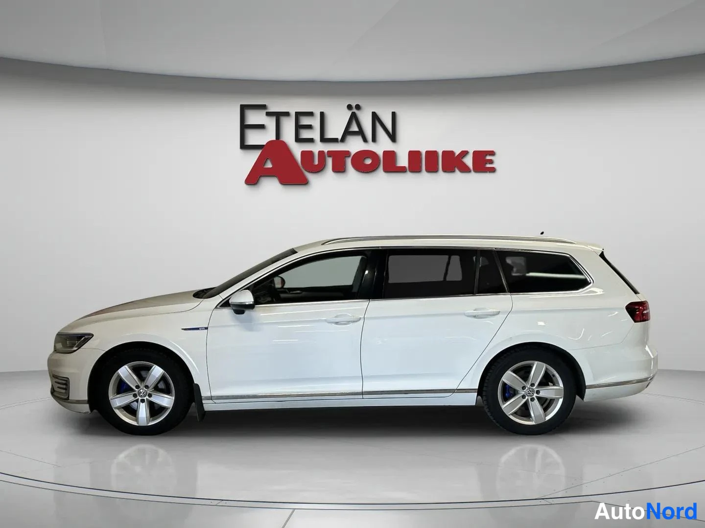 Sivulta: Valkoinen Volkswagen Passat -farmariauto sivulta kuvattuna, Etelän Autoliike -logo taustalla
