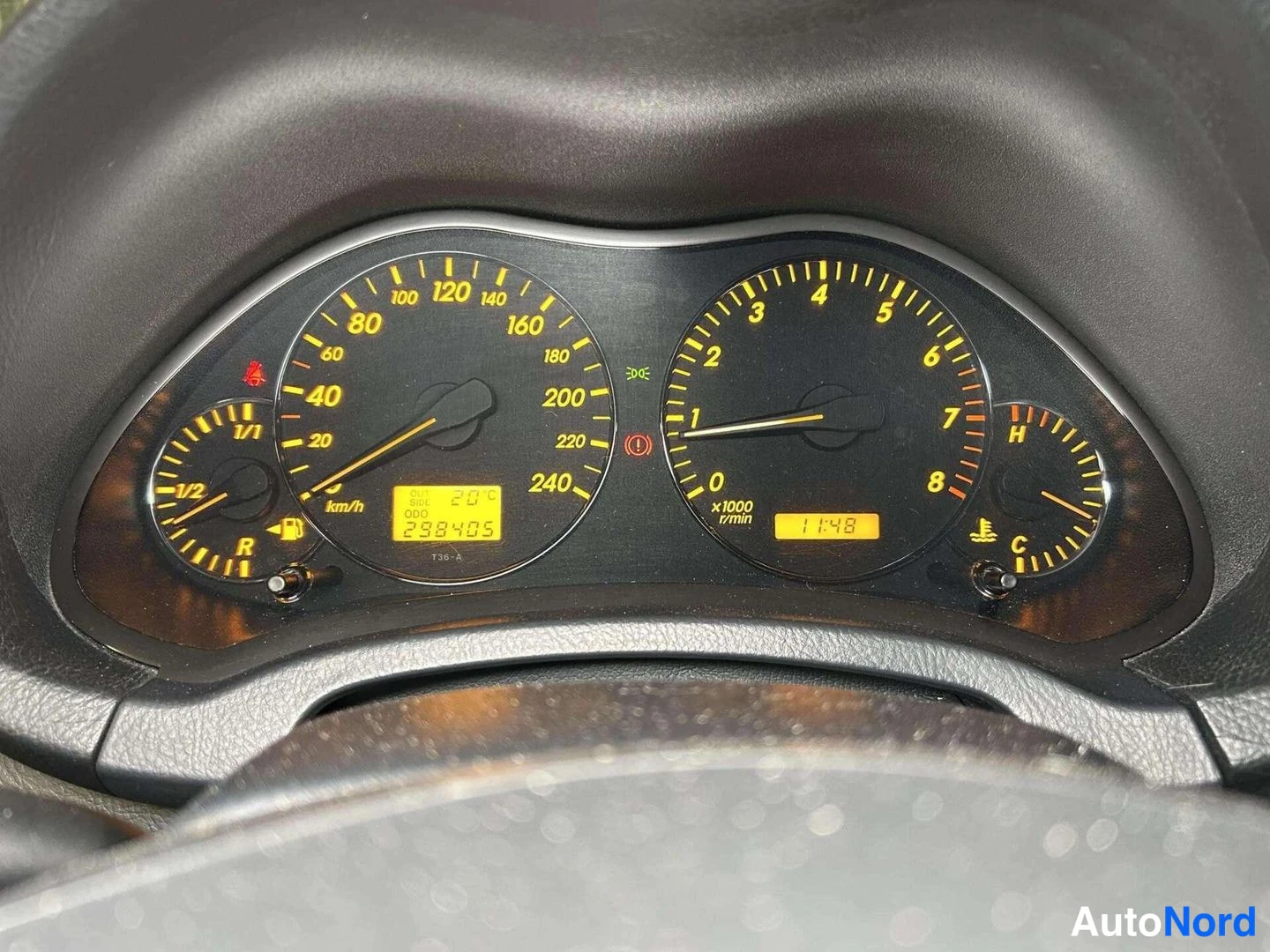 Muu: Mittaristön lähikuva oranssilla taustavalolla: nopeusmittari 240 km/h asti, kierrosmittari 8000 r/min, polttoaine- ja lämpötilamittarit sekä näyttö, jossa lukee
