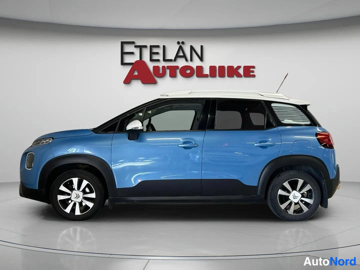 Etuviisto, nokka vasemmalle: Sinisen Citroenin etukulma-kuva vasemmalta, valkoinen katto ja Etelän Autoliike -tausta.