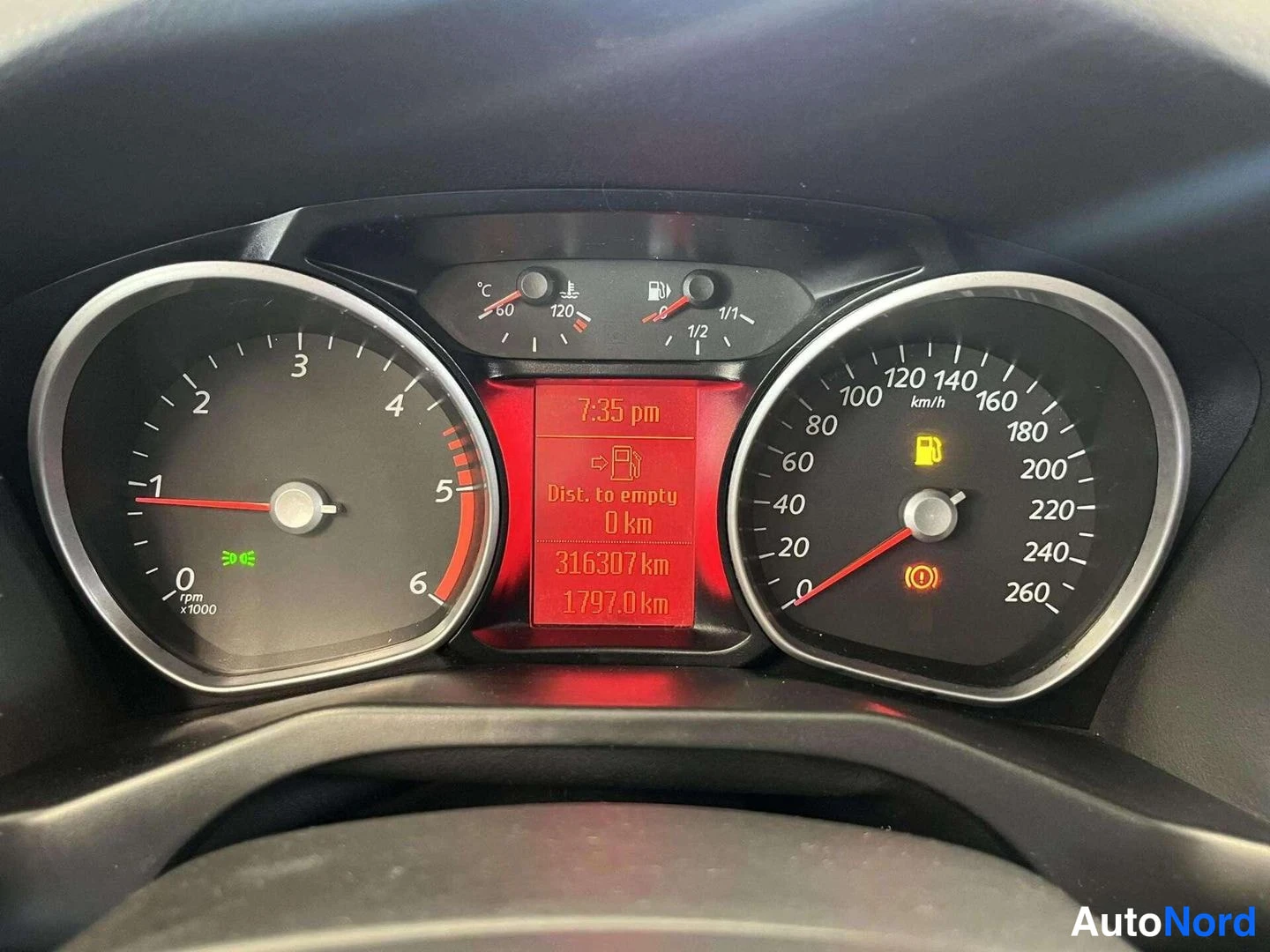 Muu: Kojetaulun mittarit lähikuvassa, näytössä 316307 km ja polttoainevaroitus.