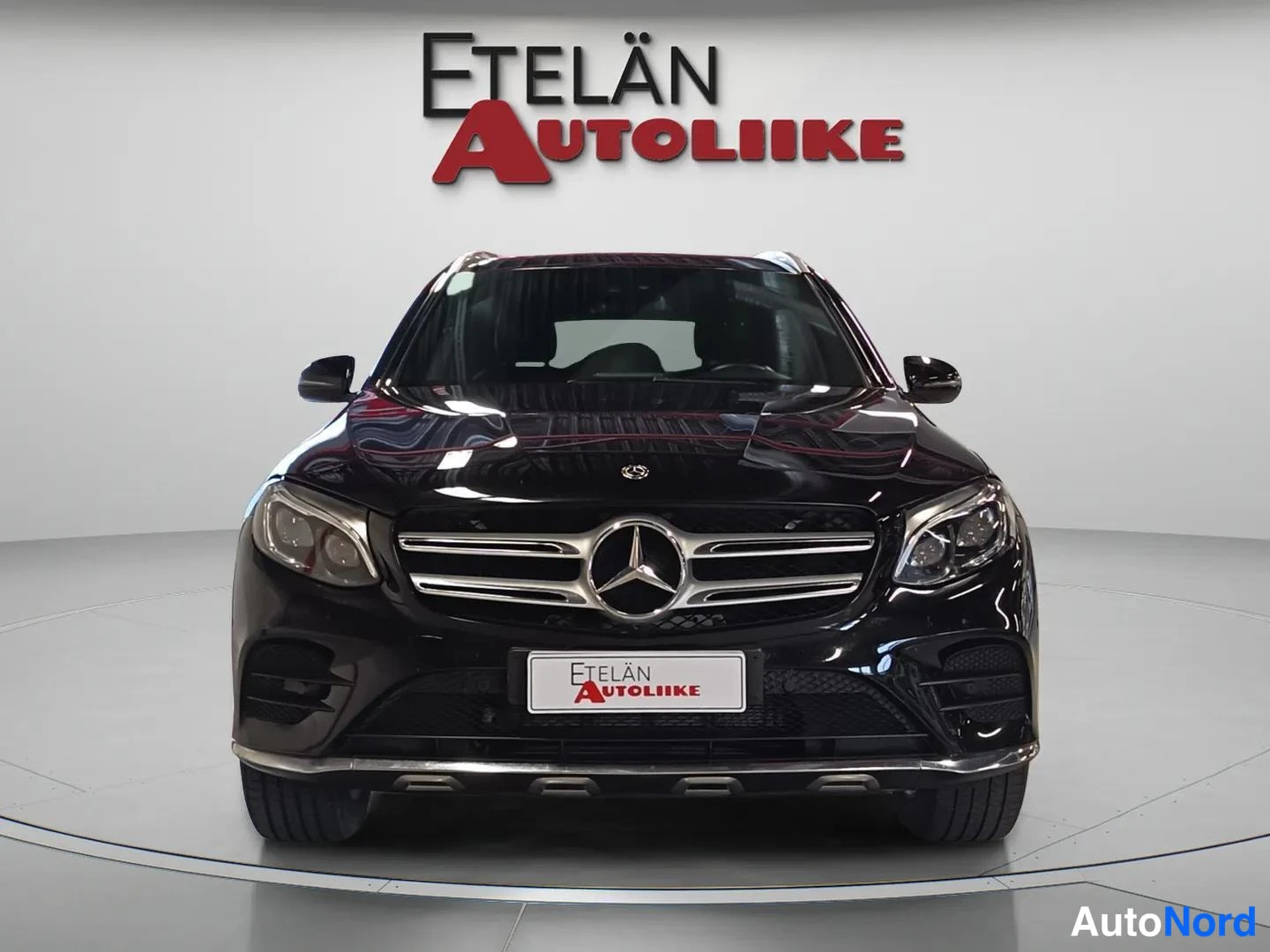 Edestä: Musta Mercedes-Benz GLC suoraan edestä valokuvattuna, Merkki-keulakoru ja Etelän Autoliike -kyltti etupuskurissa.