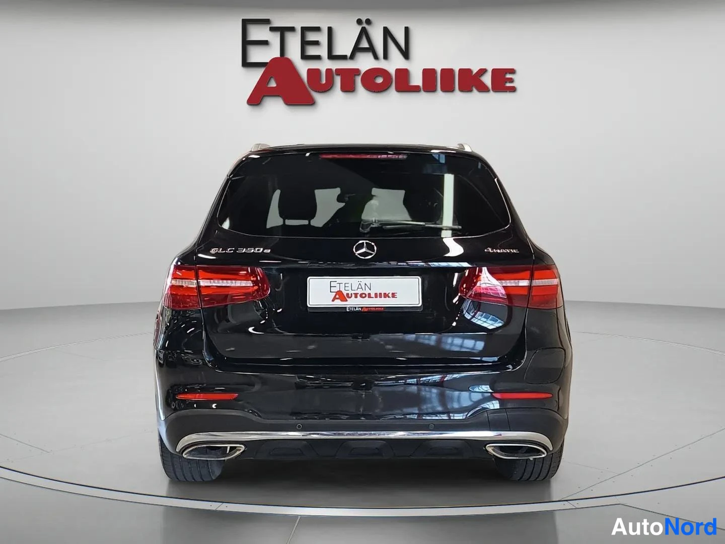 Takaa: Mustan Mercedes-Benz GLC:n takanäkymä studio-oloissa, punaiset takavalot, GLC 350 e -merkintä ja kaksoispakoputket näkyvät.