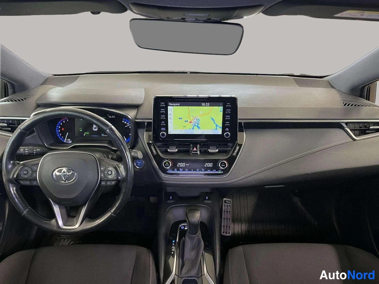 Muu: Ohjaamo suoraan edestä: Toyota-monitoimiohjauspyörä, hybridi-mittaristo, kartta kosketusnäytössä, automaattivaihteen valitsin ja kaksoisilmastoinnin lämpötilanä