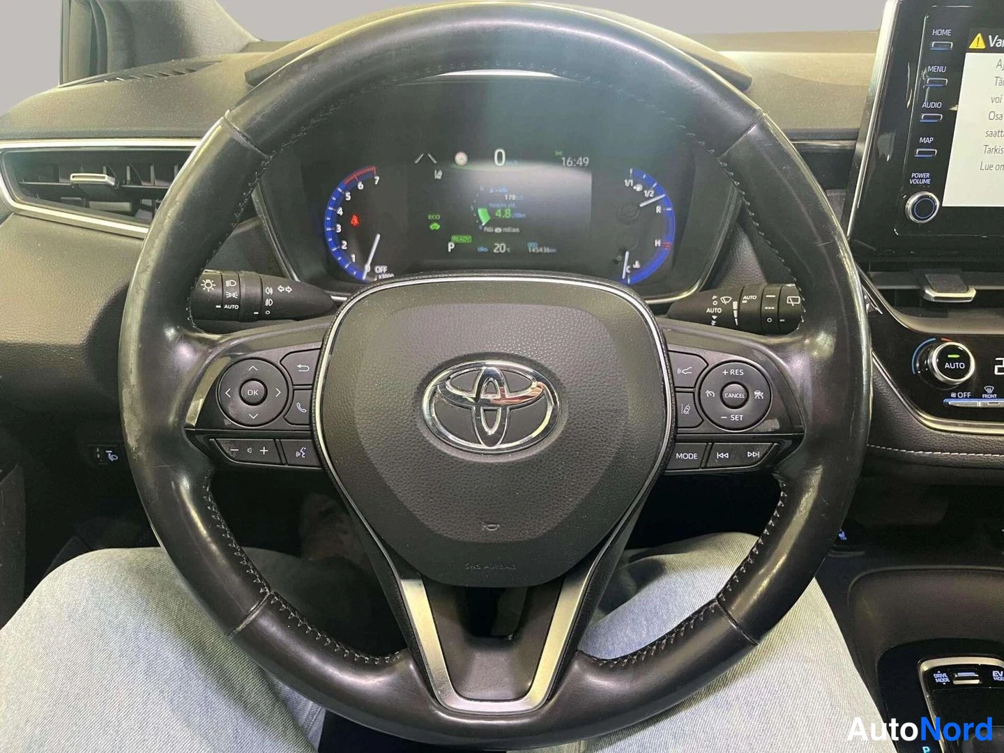 Muu: Ohjauspyörä Toyota-merkillä ja kojelaudan digitaalinäyttö; mittaristossa 145436 km, vaihde P ja READY-merkki; näytössä heijastus.