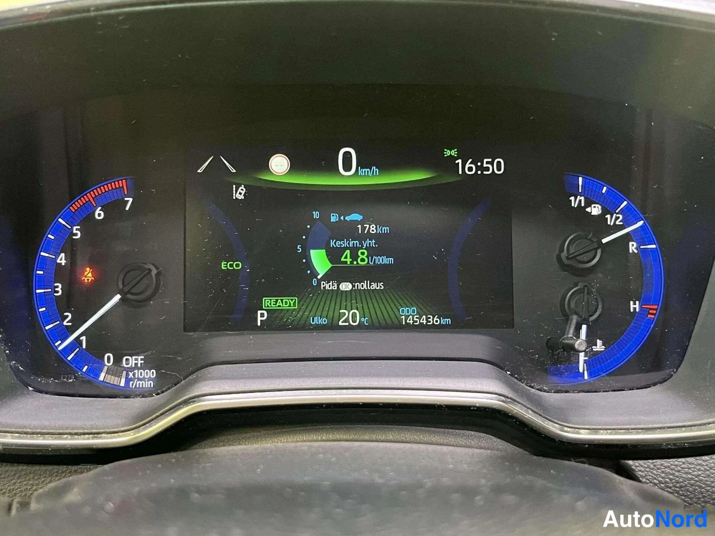 Muu: Kojelaudan mittaristön lähikuva pimeässä; näytössä 0 km/h, kellonaika 16:50, keskikulutus 4,8 l/100km, ODO 145436 km, P ja READY-merkki; kuva on melko pimeä.