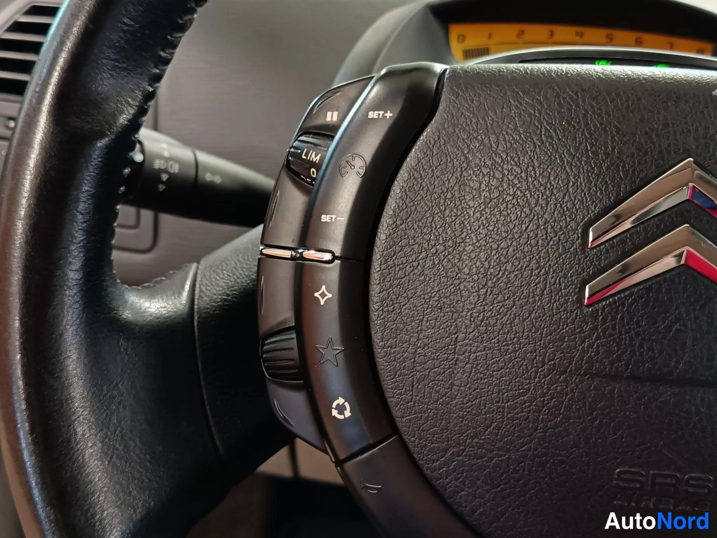Muu: Ohjauspyörän vasen puhelin/ ääniohjainnäppäimistö ja Citroënin logo; näkyy cruise control -merkkivalo ja rattiin merkitty SRS AIRBAG -teksti.