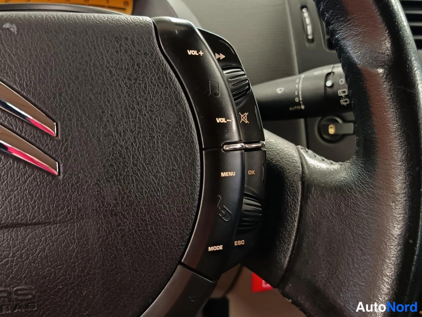 Muu: Ohjauspyörän oikeanpuoleiset äänentoiston säädinnäppäimet (VOL+, VOL-, MENU, MODE, ESC, OK) ja Citroënin logo; takana valokytkin.