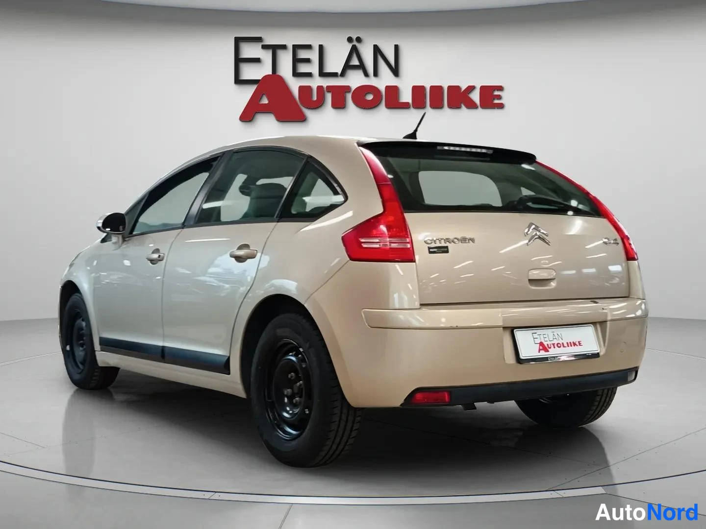 Takaviisto: Beige Citroën C4 -auton takaosa ja vasen kylki studiotaustaa vasten, takaluukissa Citroën-merkintä.