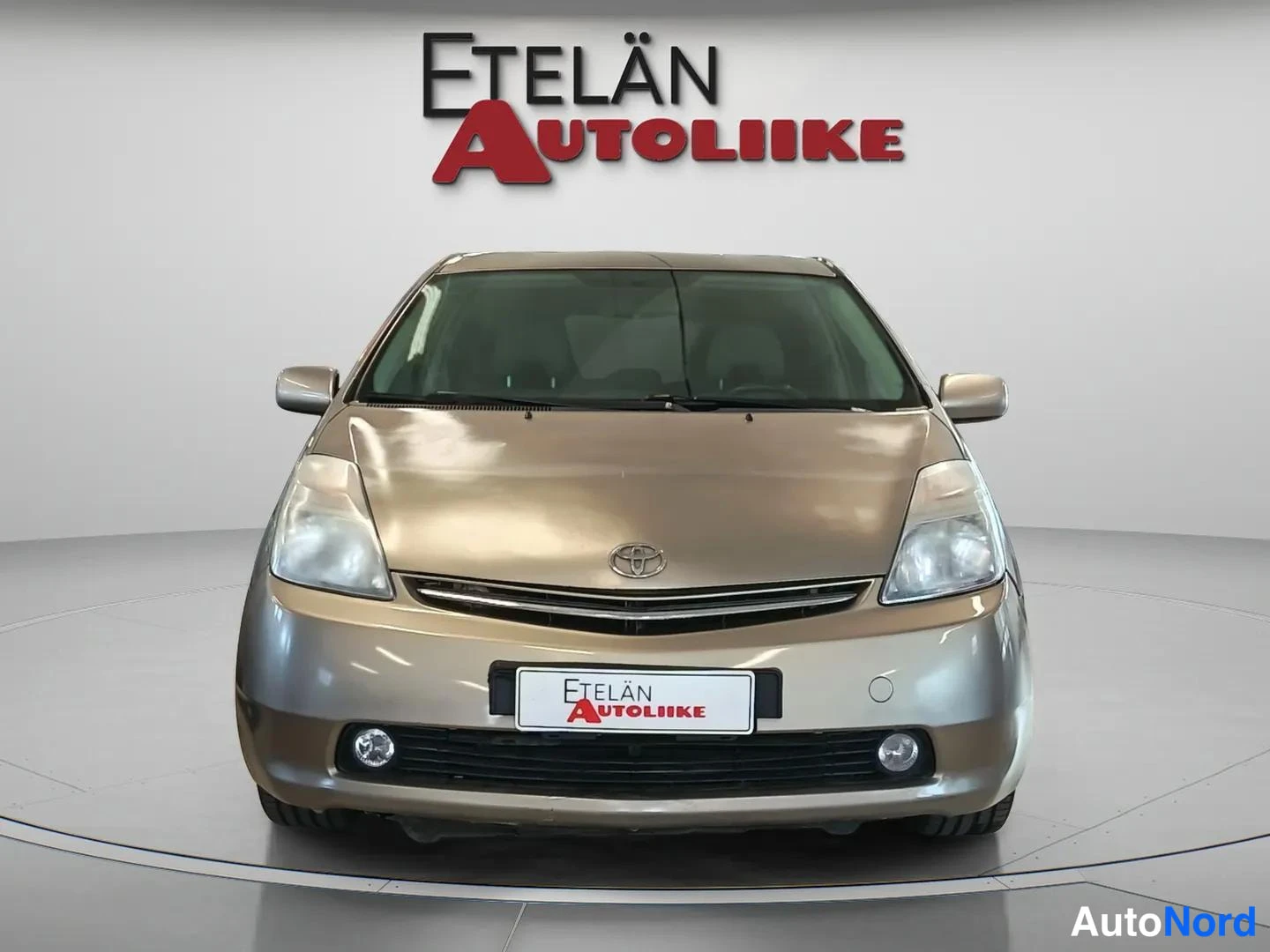 Edestä: Toyota Prius 2008, suora edustakuva; edessä hybridisynergia-merkki ja sumuvalot, tutkimatonta edessä.