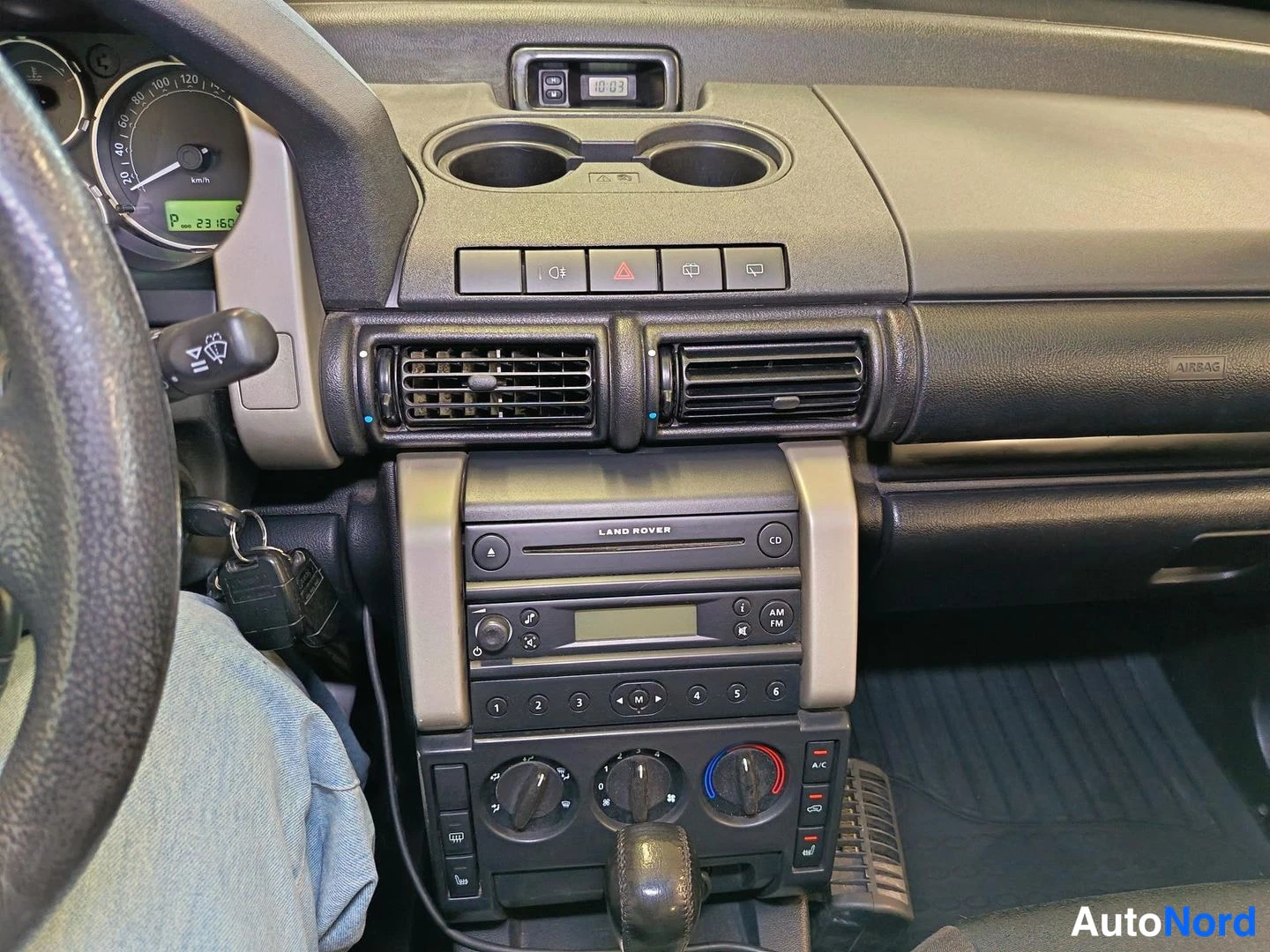 Muu: Kojelauta vasemmalta: nopeusmittari, kello 19:03, kaksi kuppitelineessä, Land Roverin CD-radio ja A/C-säädöt, automaattivaihteen valitsin.