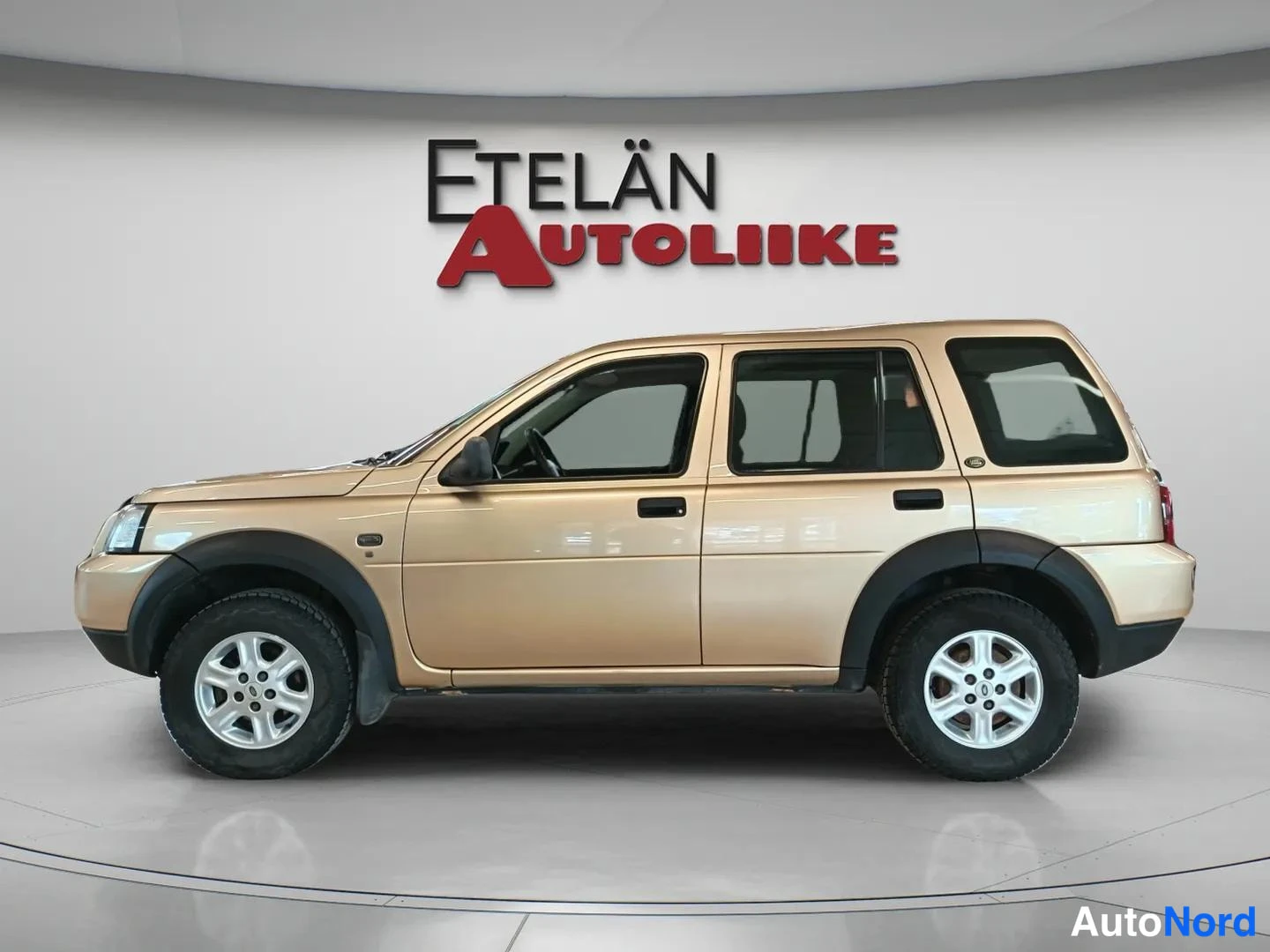 Sivulta: Beige Land Rover Freelander -kylkikuva studiossa, Etelän Autoliike-tausta.
