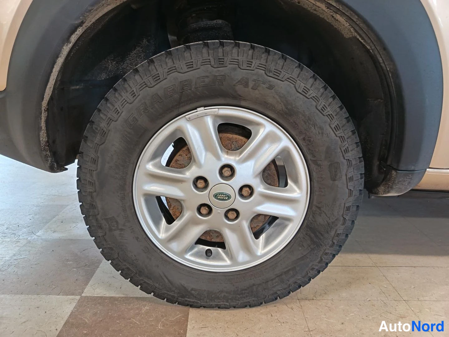 Muu: Hopeinen kevytmetallivanne Land Rover -keskiöllä, rengas General Grabber AT3.