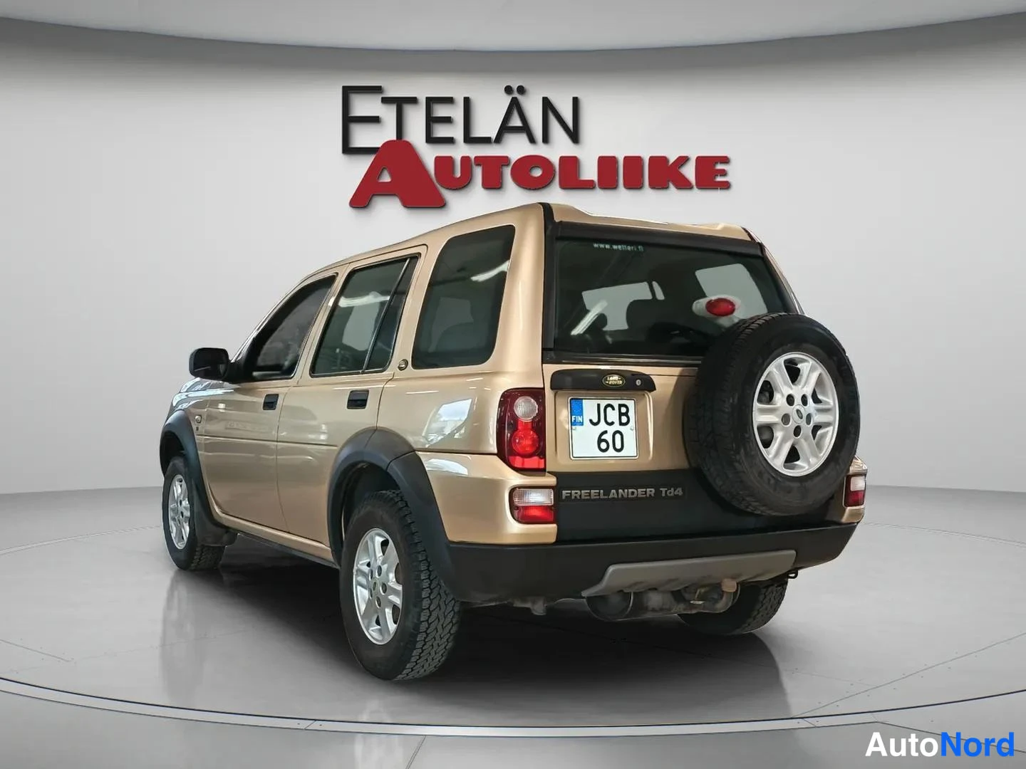 Takaviisto: Beige Land Rover Freelander Td4 -takakulma varapyörä takaosassa, rekisteri JCB 60, Etelän Autoliike-tausta.