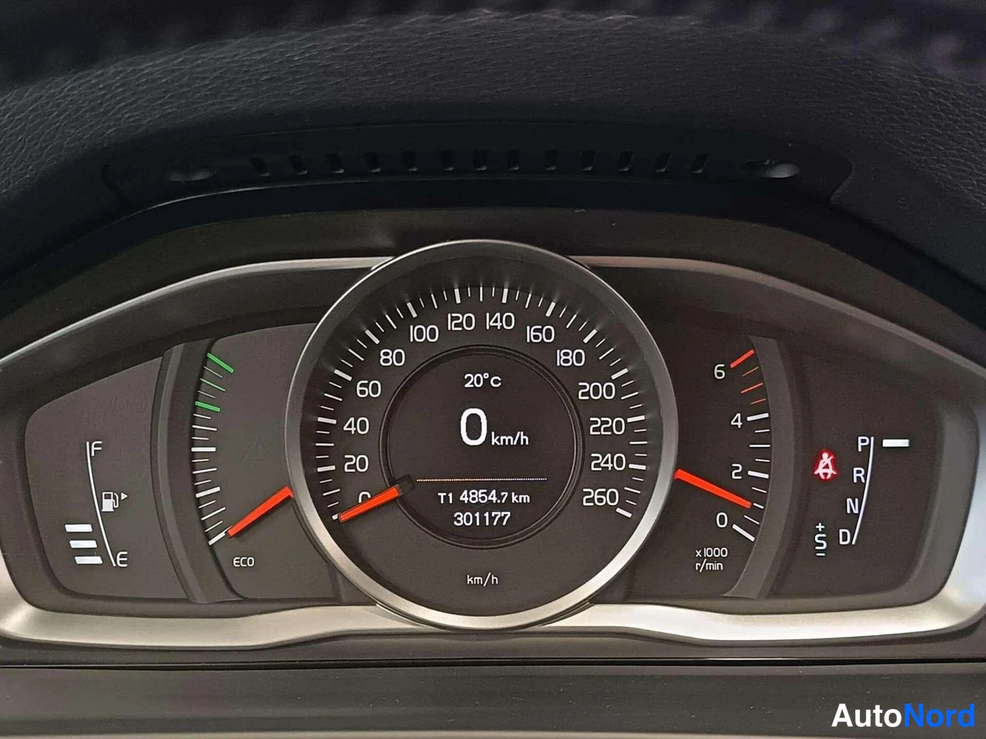 Muu: Auton mittaristo: nopeusmittari 0 km/h, kokonaislukema 301177 km, lämpötila 20 °c ja vaihtoasemat P, R, N, D.