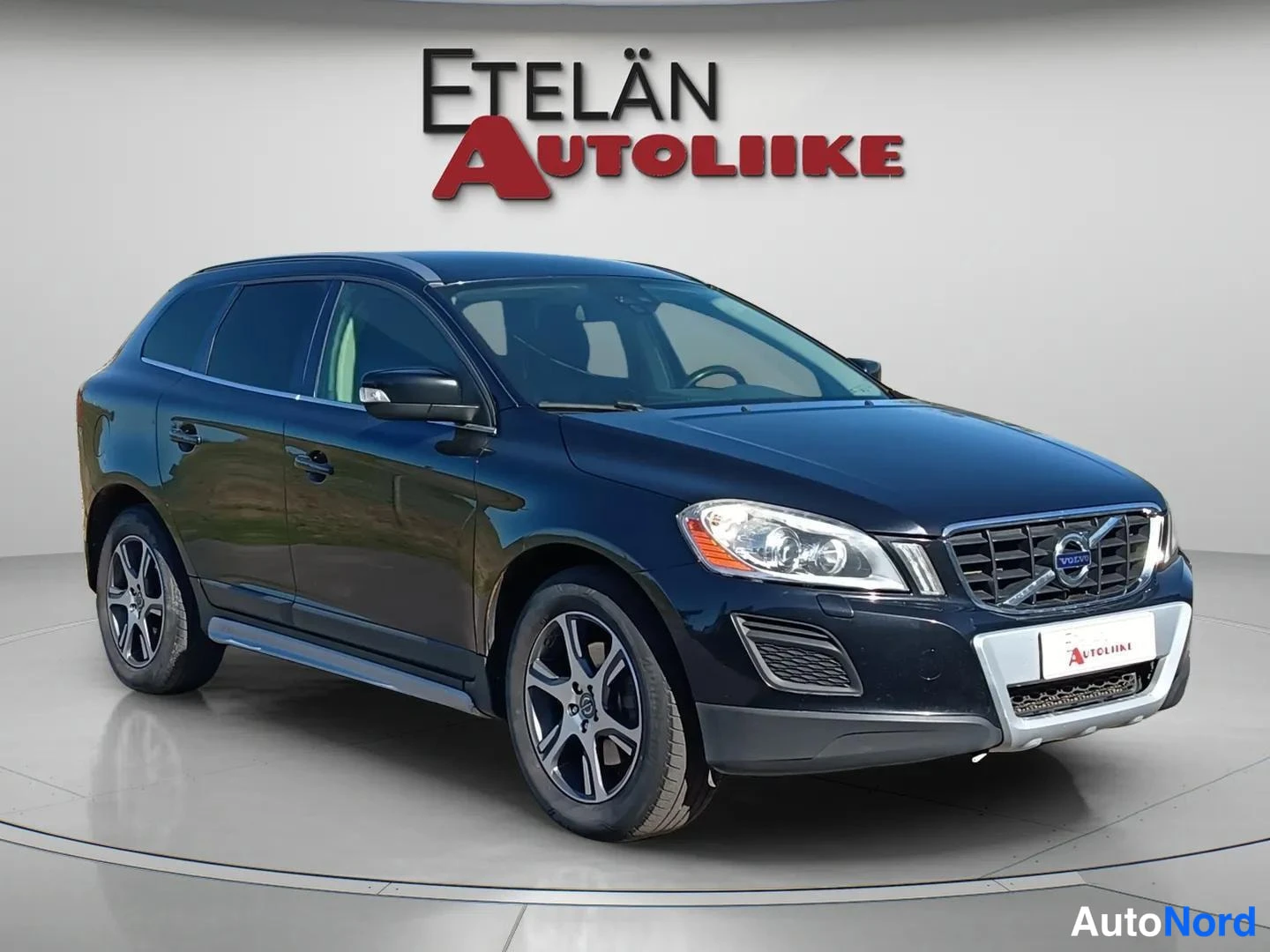 Etuviisto, nokka oikealle: Volvo XC60 -maasturin etunurkka ja sivu valokuvastudiossa, musta kori