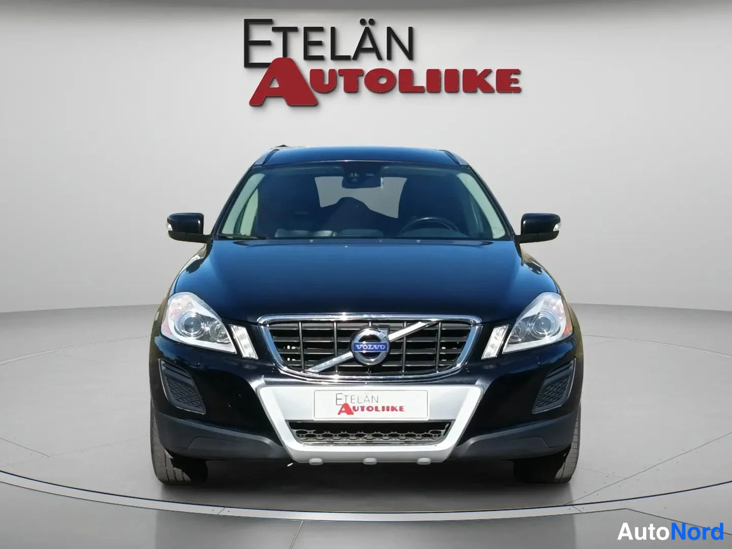 Edestä: Volvo XC60:n etunäkymä suoraan edestä, musta kori ja eteisvalot