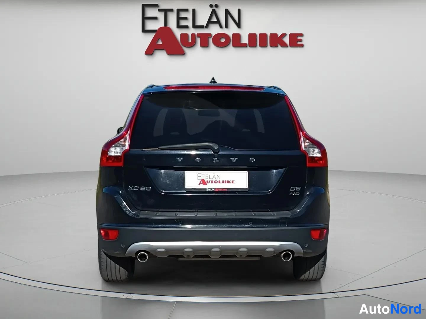 Takaa: Mustan auton suora takanäkymä, kohovalot ja kaksi pakoputkea, Etelän Autoliike -kilpi takaluukussa.