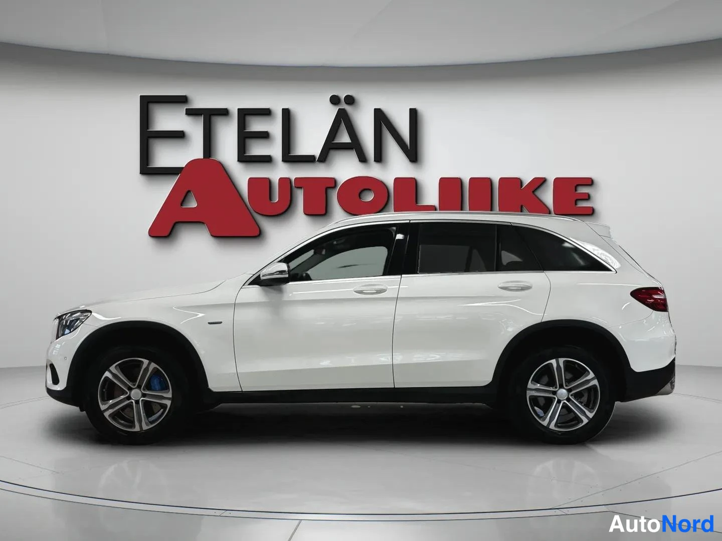 Etuviisto, nokka vasemmalle: Valkoinen Mercedes-Benz GLC kyljenäkökulmasta, keulan etupyörä ja ajovalo näkyvissä vasemmassa reunassa.