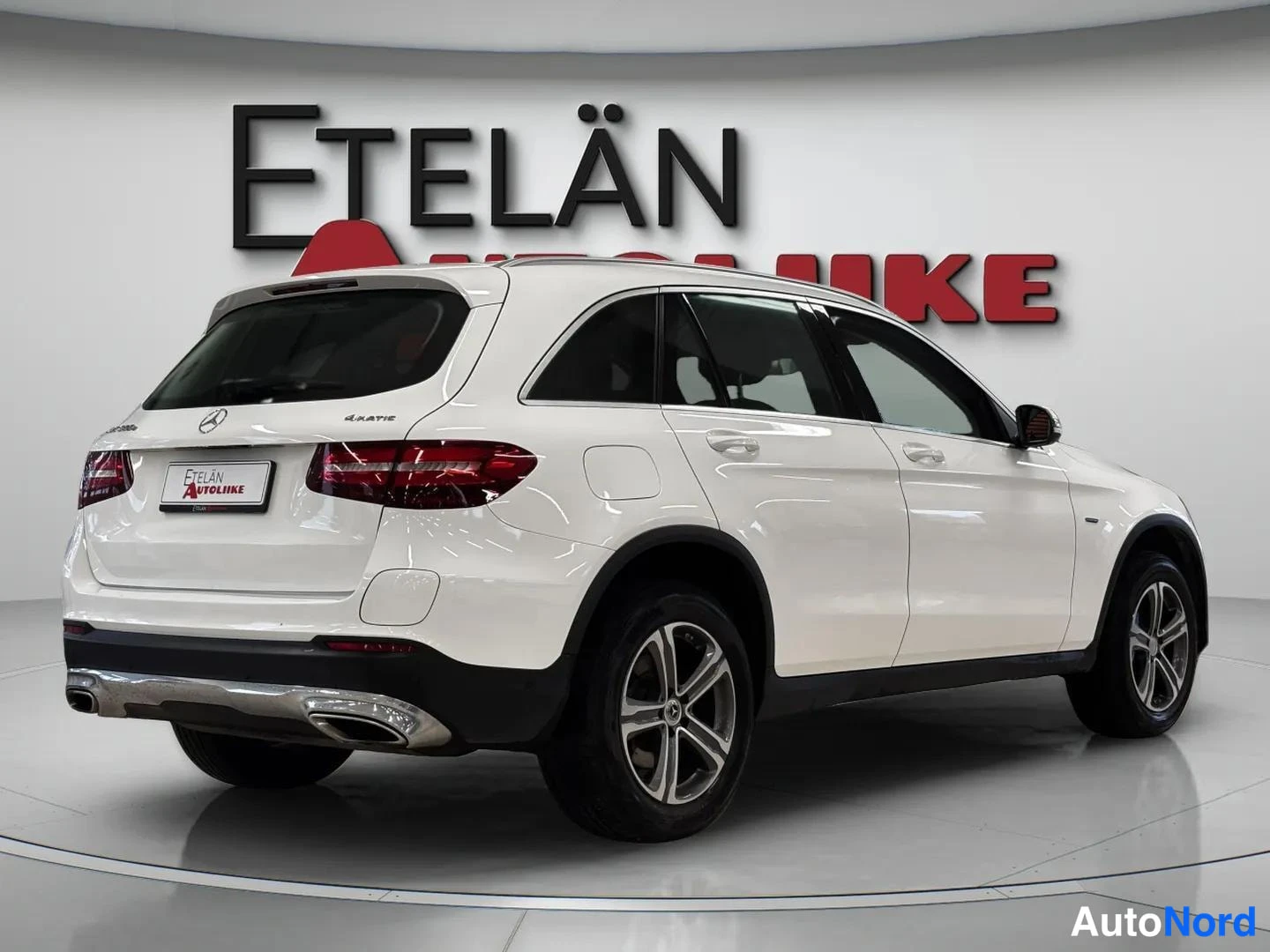 Takaviisto: Takakulmanäyttö: valkoinen Mercedes-Benz GLC -maasturi sivusuunnasta, jossa näkyvät takavalot, kylkilinjat ja Hopea vanteet.