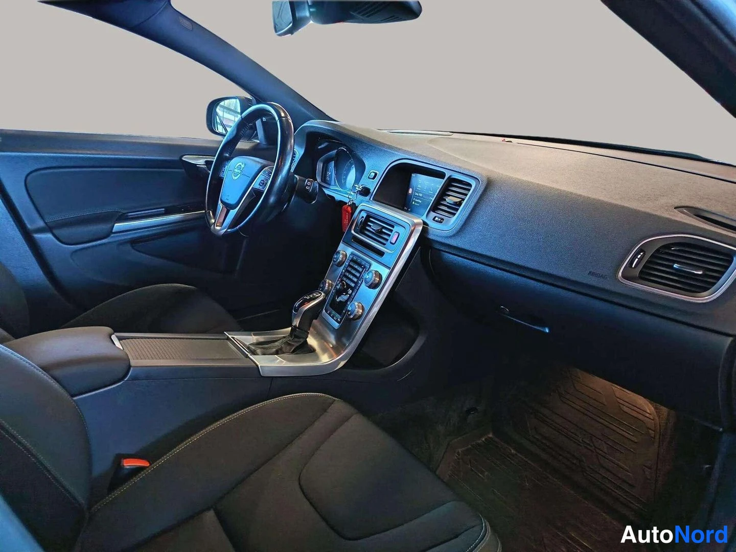 Etuviisto, nokka vasemmalle: Volvo V60 dashboard and centre console with gear selector photographed from the passenger side