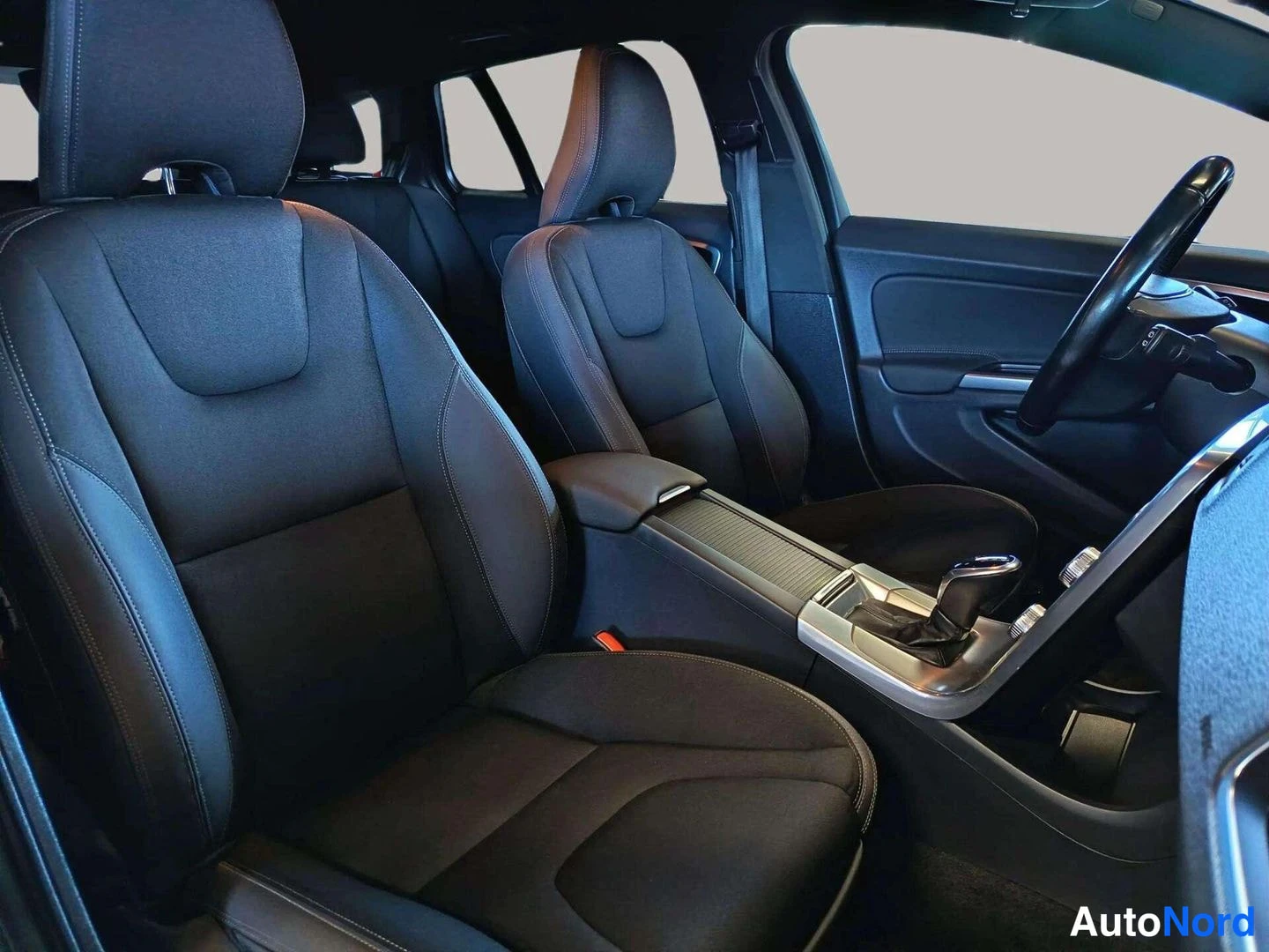 Etuviisto, nokka vasemmalle: Volvo V60 front seats and centre console with gear selector photographed from behind