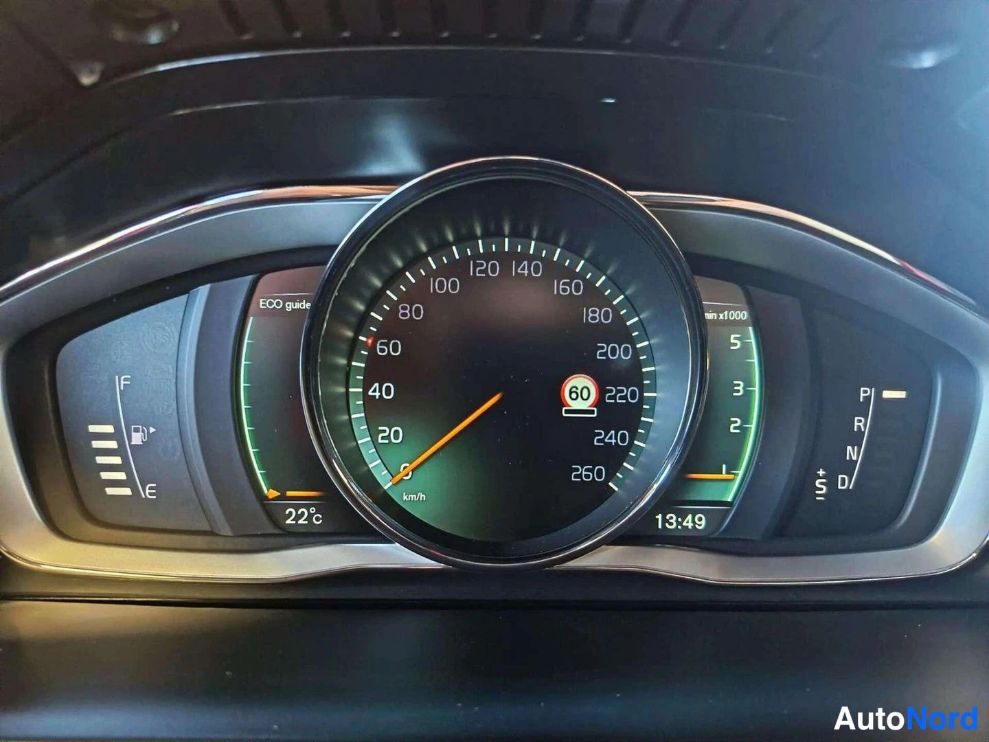 Muu: Auton kojelaudan mittaristo: nopeusmittari asteikolla 0–260 km/h, polttoainemittari vasemmalla, vaihdelaatikon tila P R N D oikealla sekä näytössä kello 13:49 j