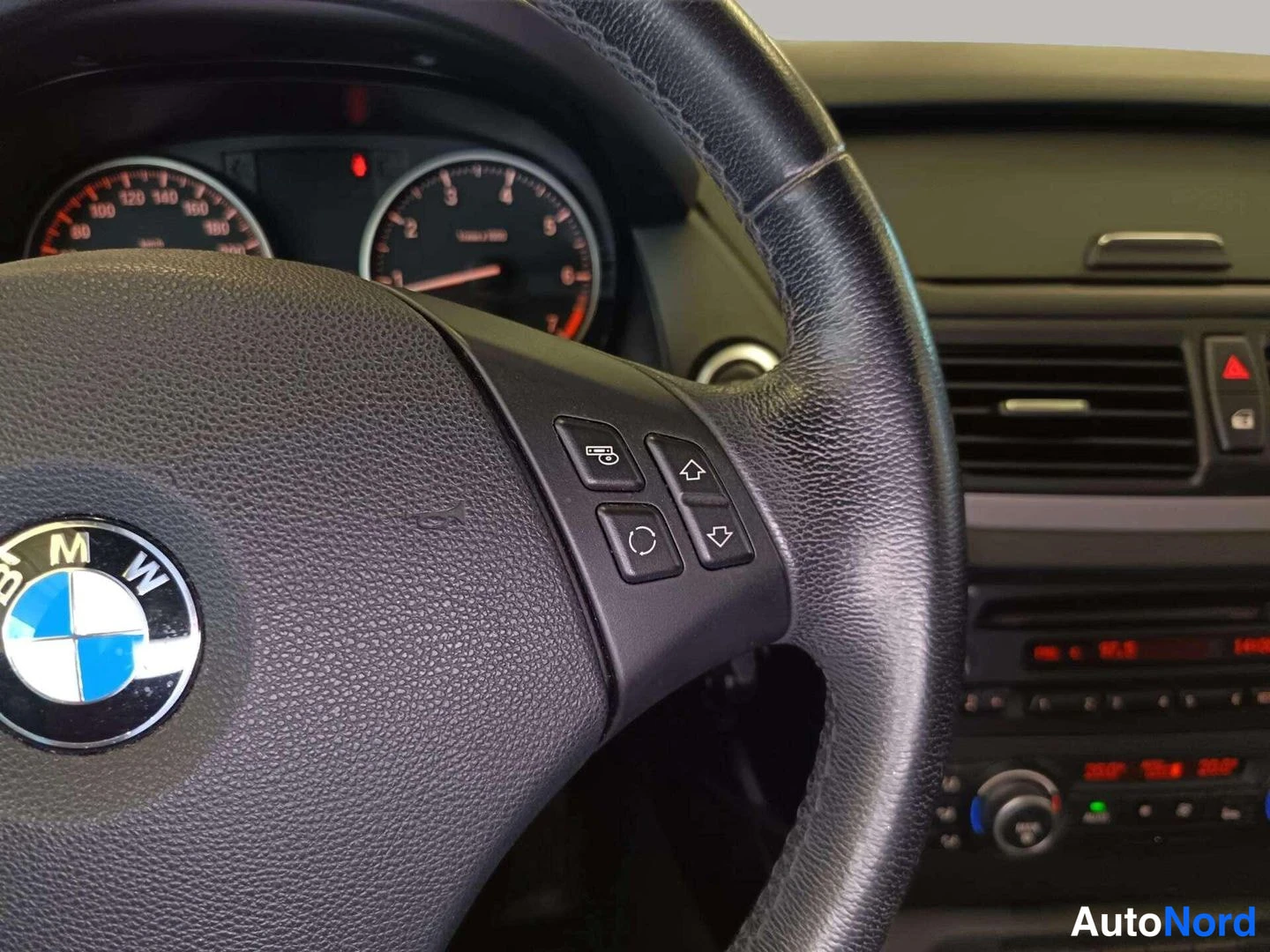 Muu: BMW-merkkinen ohjauspyörä ja mittaristo auton sisätiloissa.