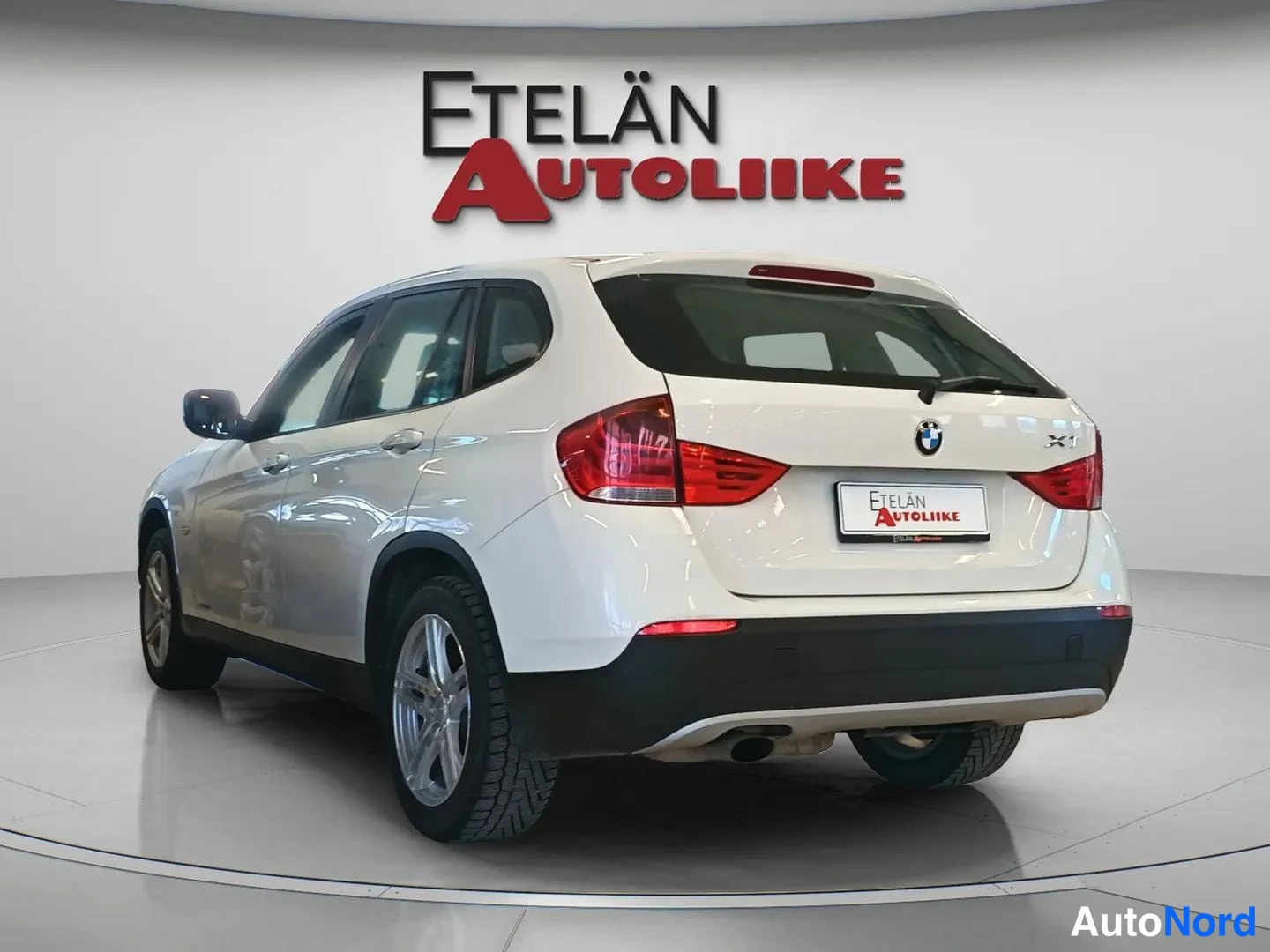 Takaviisto: Valkoinen BMW X1 takaa vasemmalta kuvattuna; X1-merkintä takaluukussa.