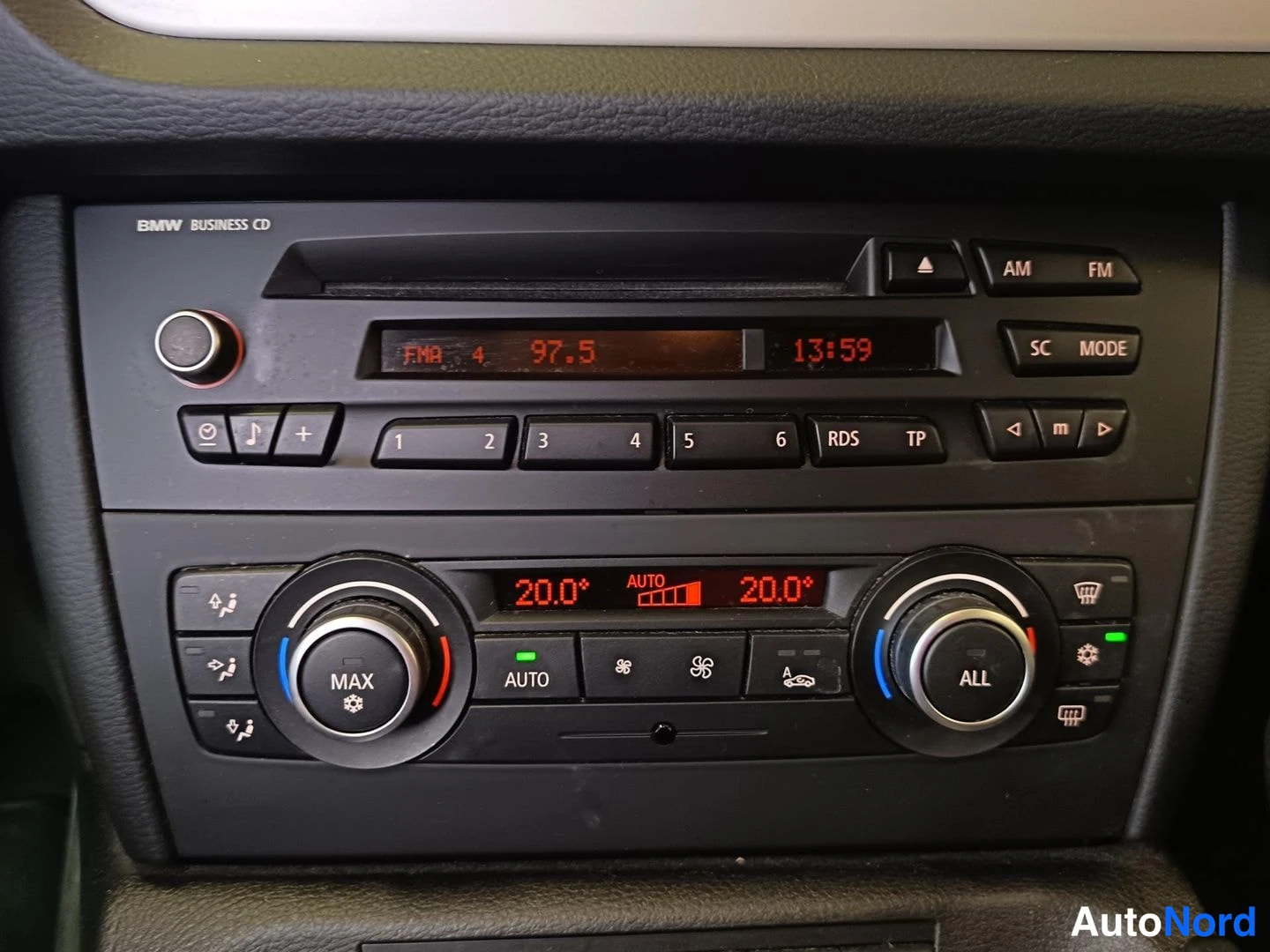 Muu: Radio- ja ilmastointipaneeli lähikuvassa: näytössä FM 4 97.5 ja 13:59, molempien puolien lämpötila 20.0°, AUTOnapit ja pyöristyksen MAX- ja ALL-säätimet